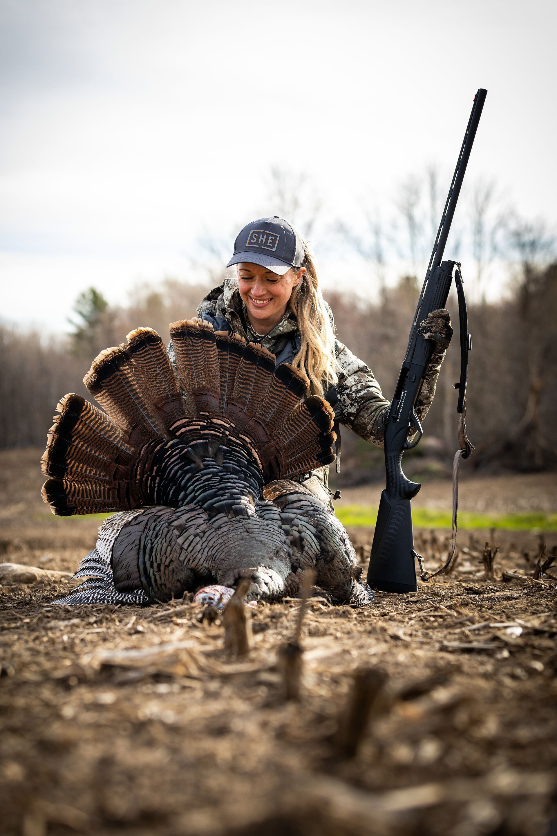 Female hunter with shotgun and turkey after hunt, Minnesota turkey season concept.