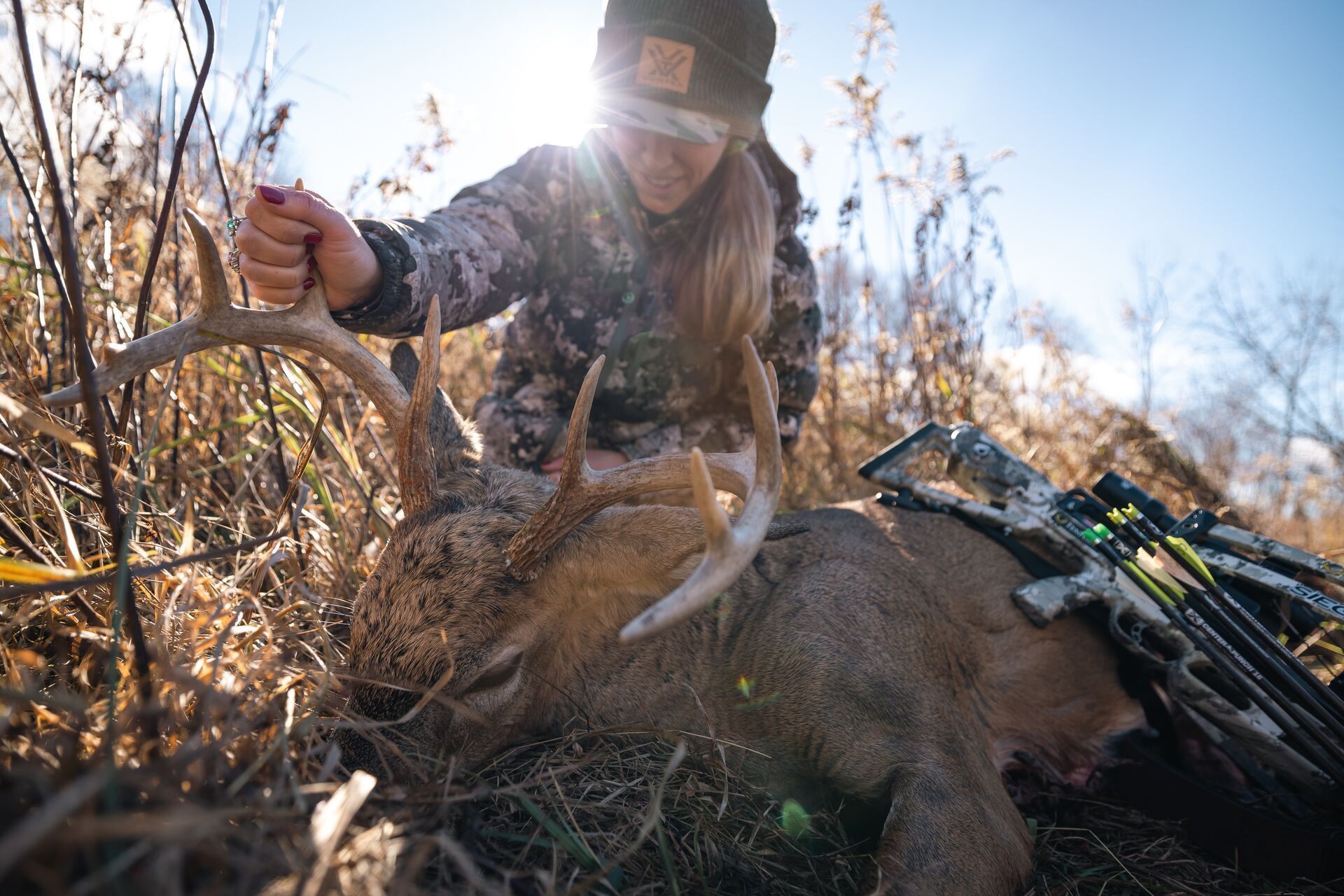 Female hunter shows off buck after hunt, deer hunting season in South Dakota concept.