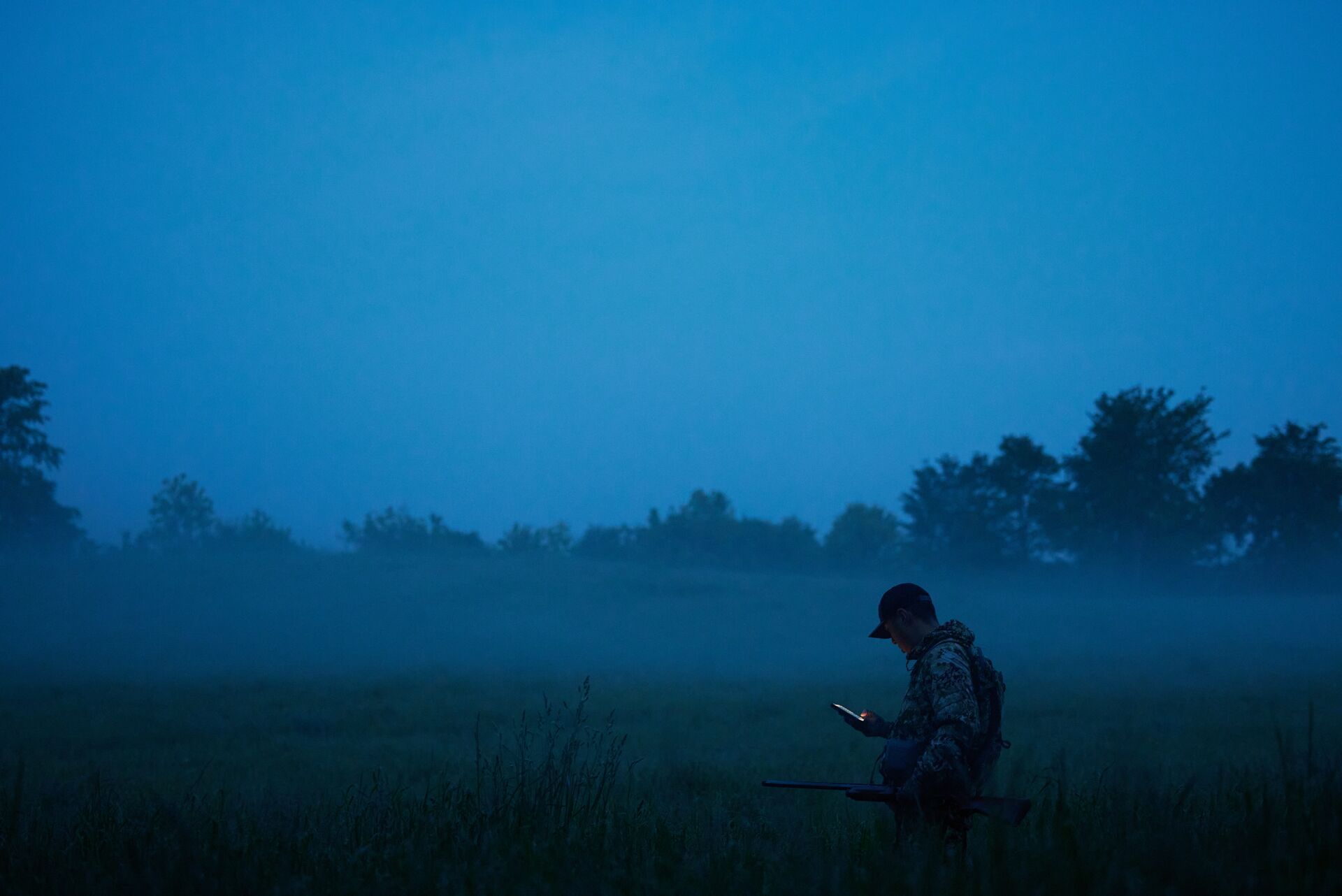 a-hunter-using-the-huntwise-app-at-dawn-using-deer-calls-concept. 