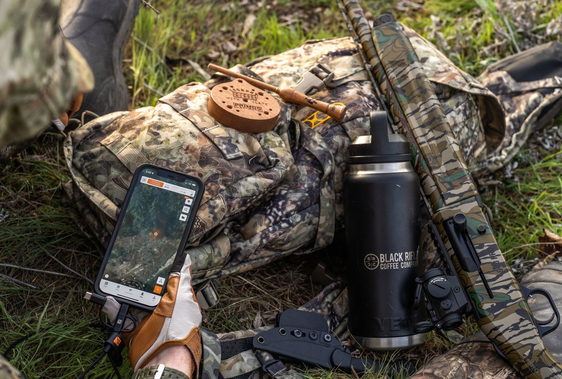 Close-up of a phone screen with HuntWise and other gear nearby, identify button bucks concept.