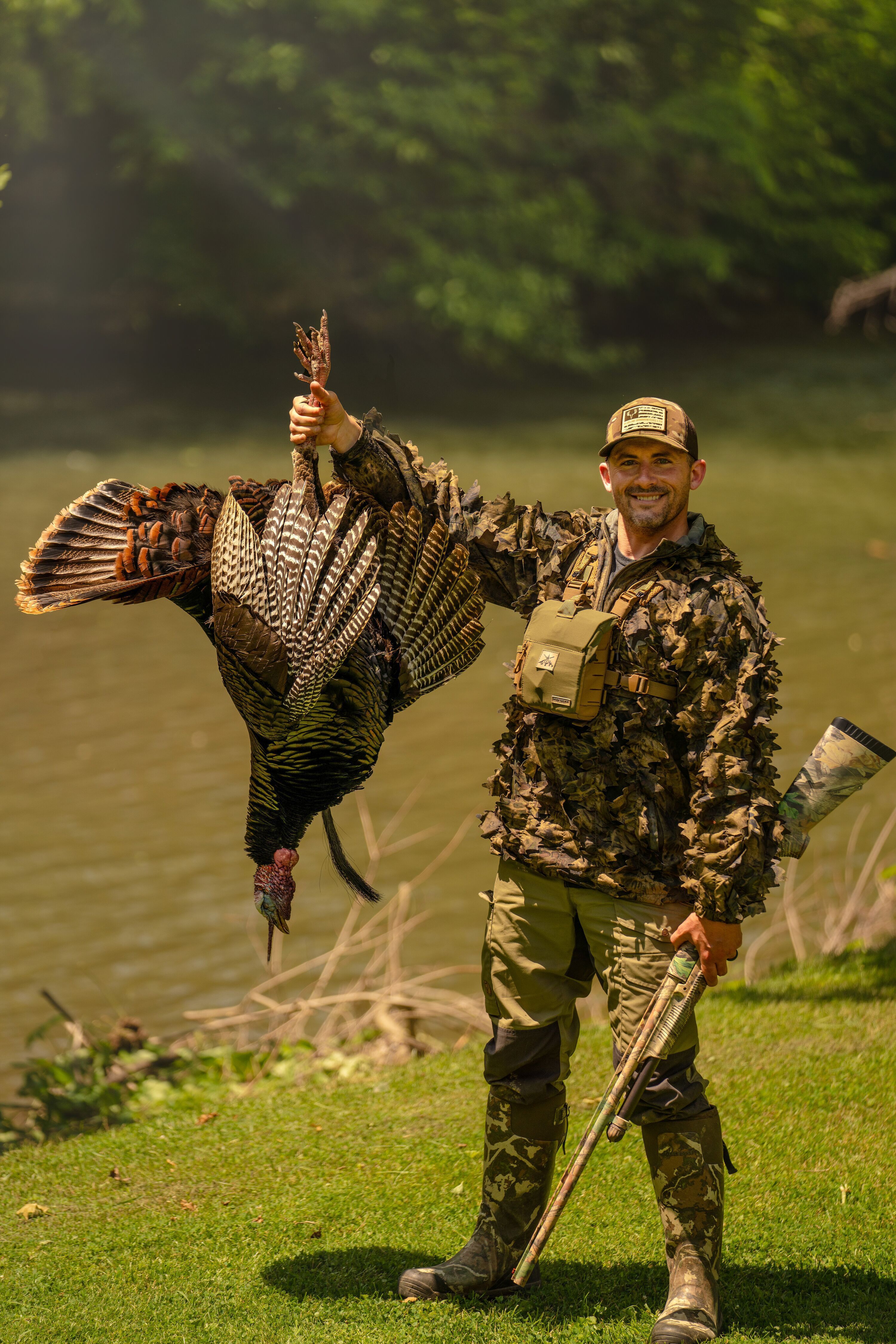 Hunter smiles and holds up a turkey after hunt, Indiana turkey hunting concept.