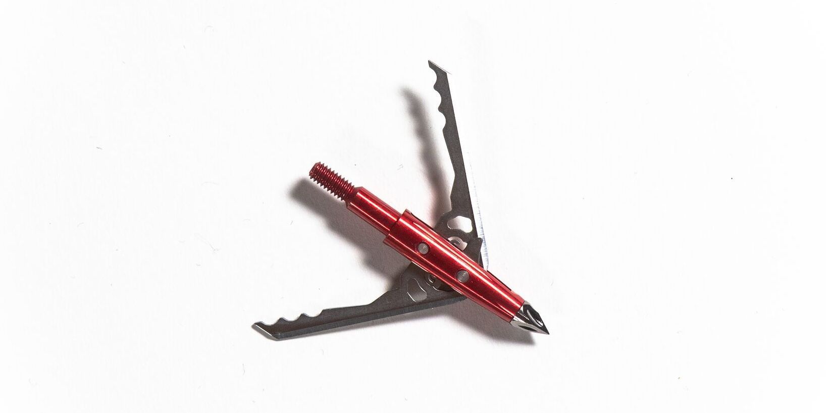 A red broadhead on a white background, mechanical vs fixed broadheads concept.
