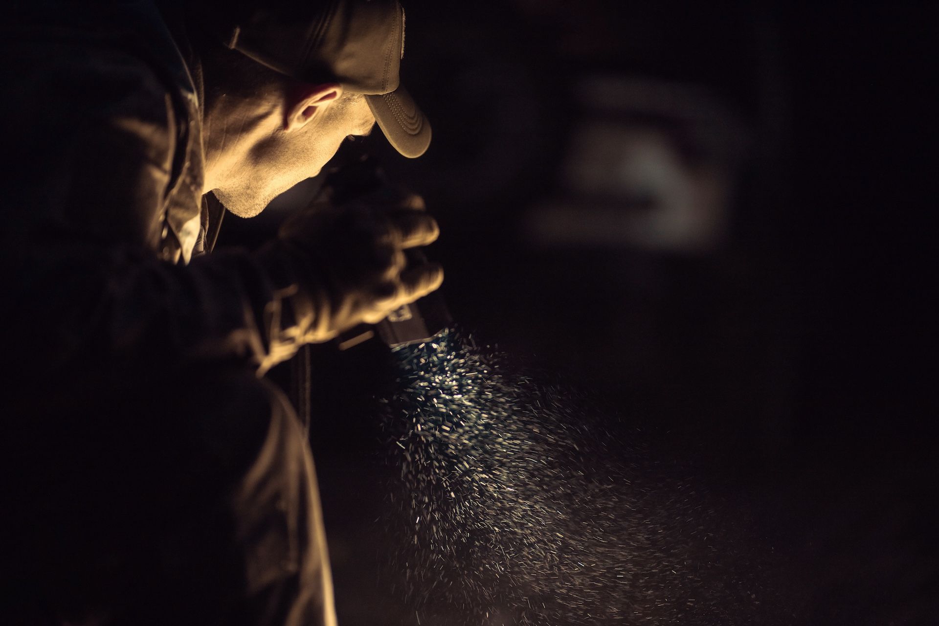 A hunter holds a flashlight in the dark, coyote hunting at night concept.