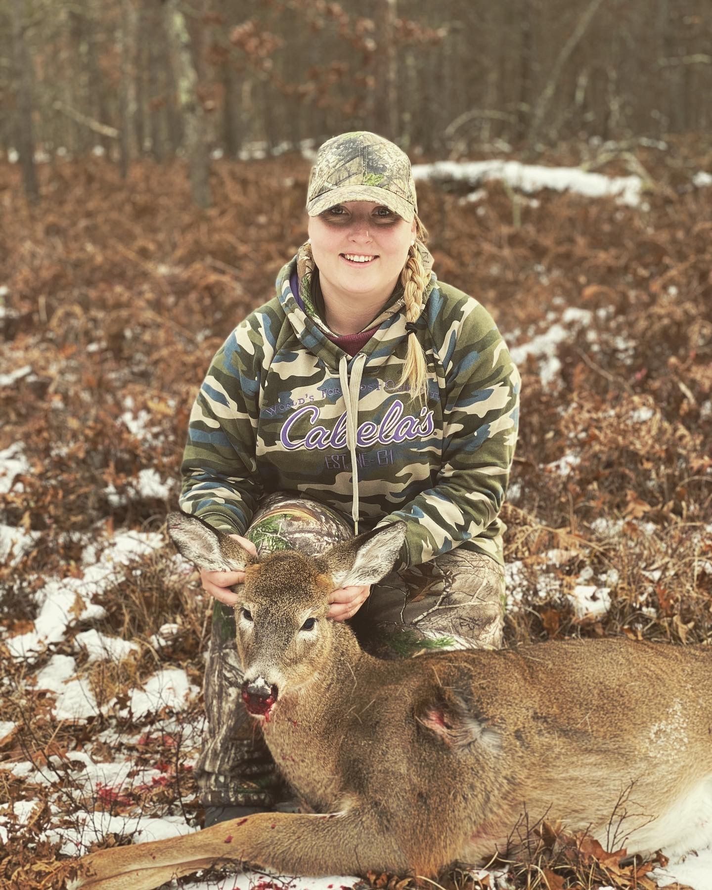 A female hunter with a button buck, hunting from a tree stand concept.