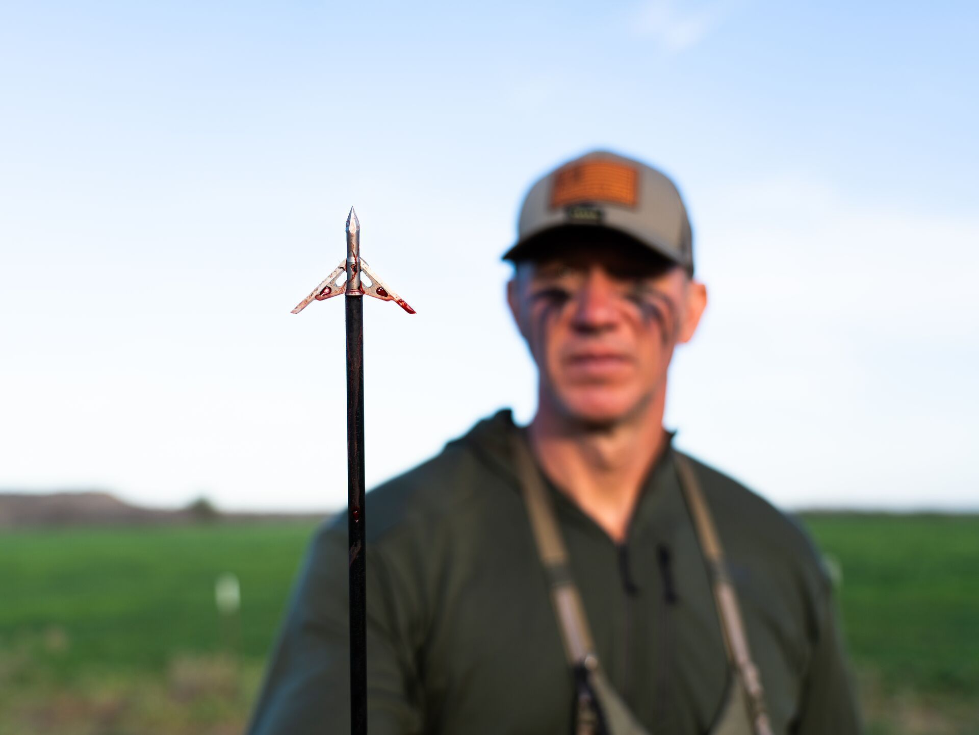 John Dudley looks at an arrow broadhead, use the HuntWise hunting app for successful hunts concept.