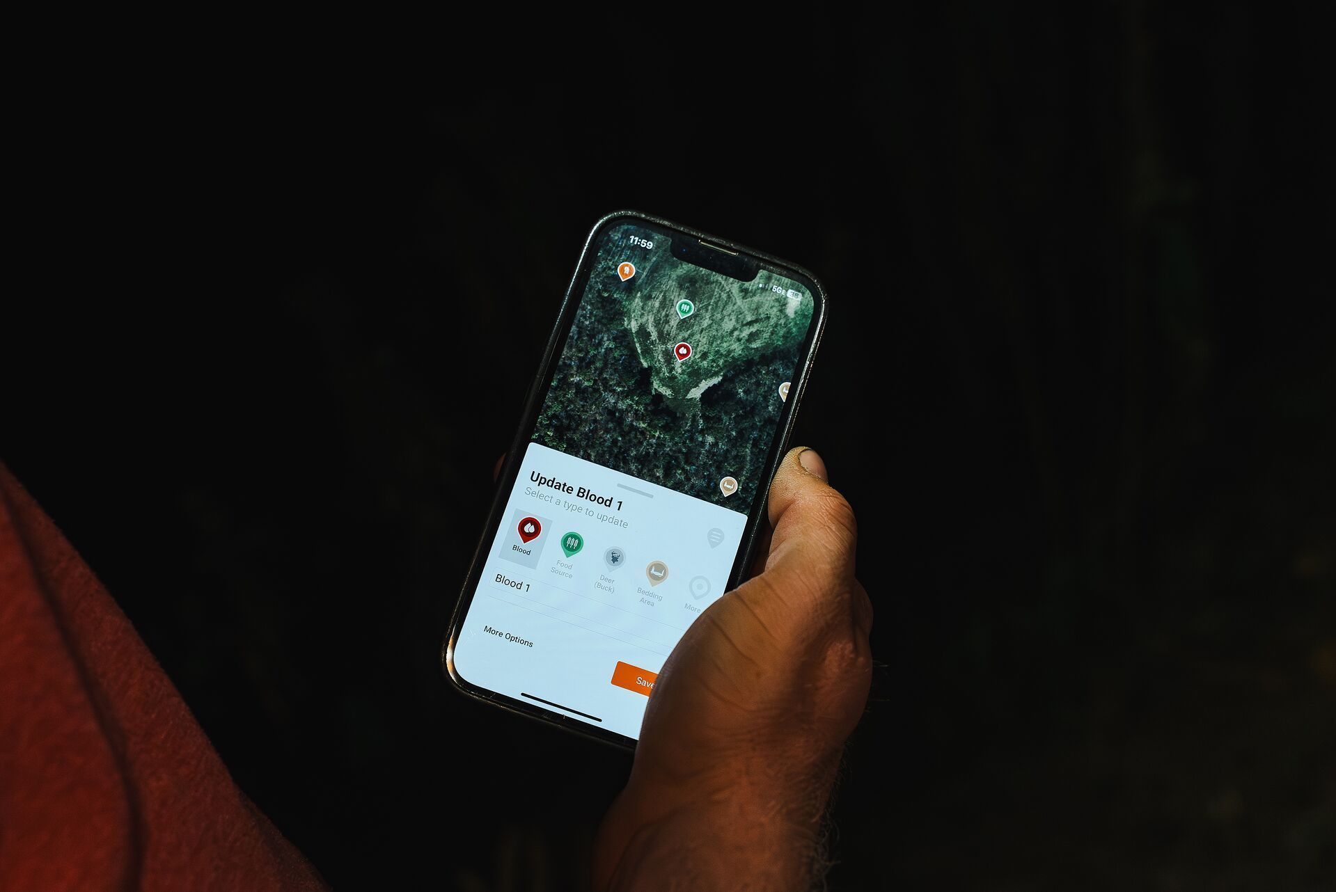 Close-up of hands holding a phone showing HuntWise pins, HuntWise review concept.