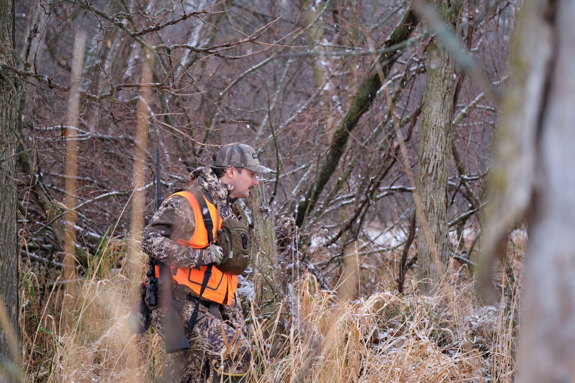 A hunter dressed in cold weather gear while hunting deer.
