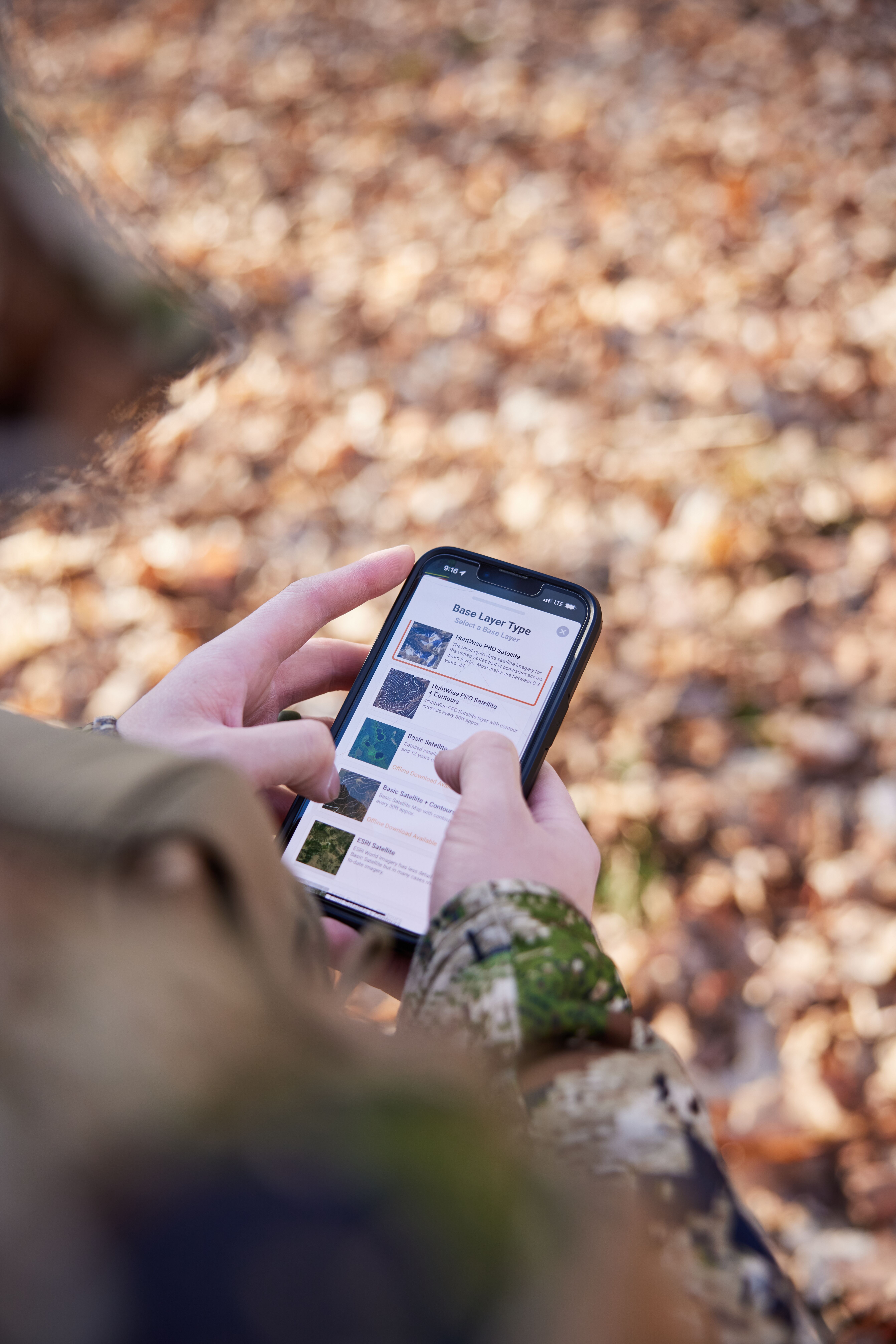 Hunter holding a phone showing HuntWise on screen.