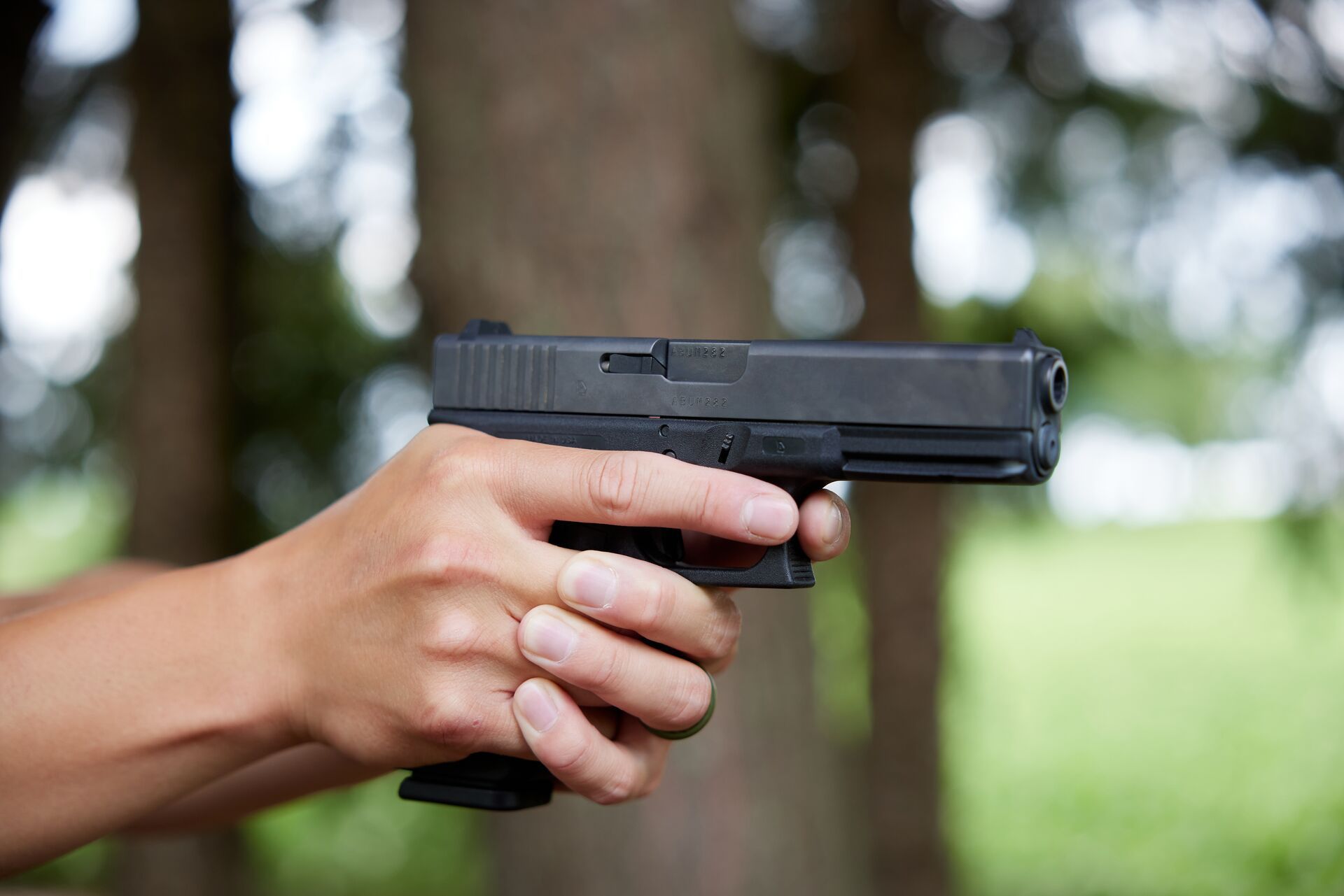 Close-up of hands holding a handgun, hog hunting supplies concept.