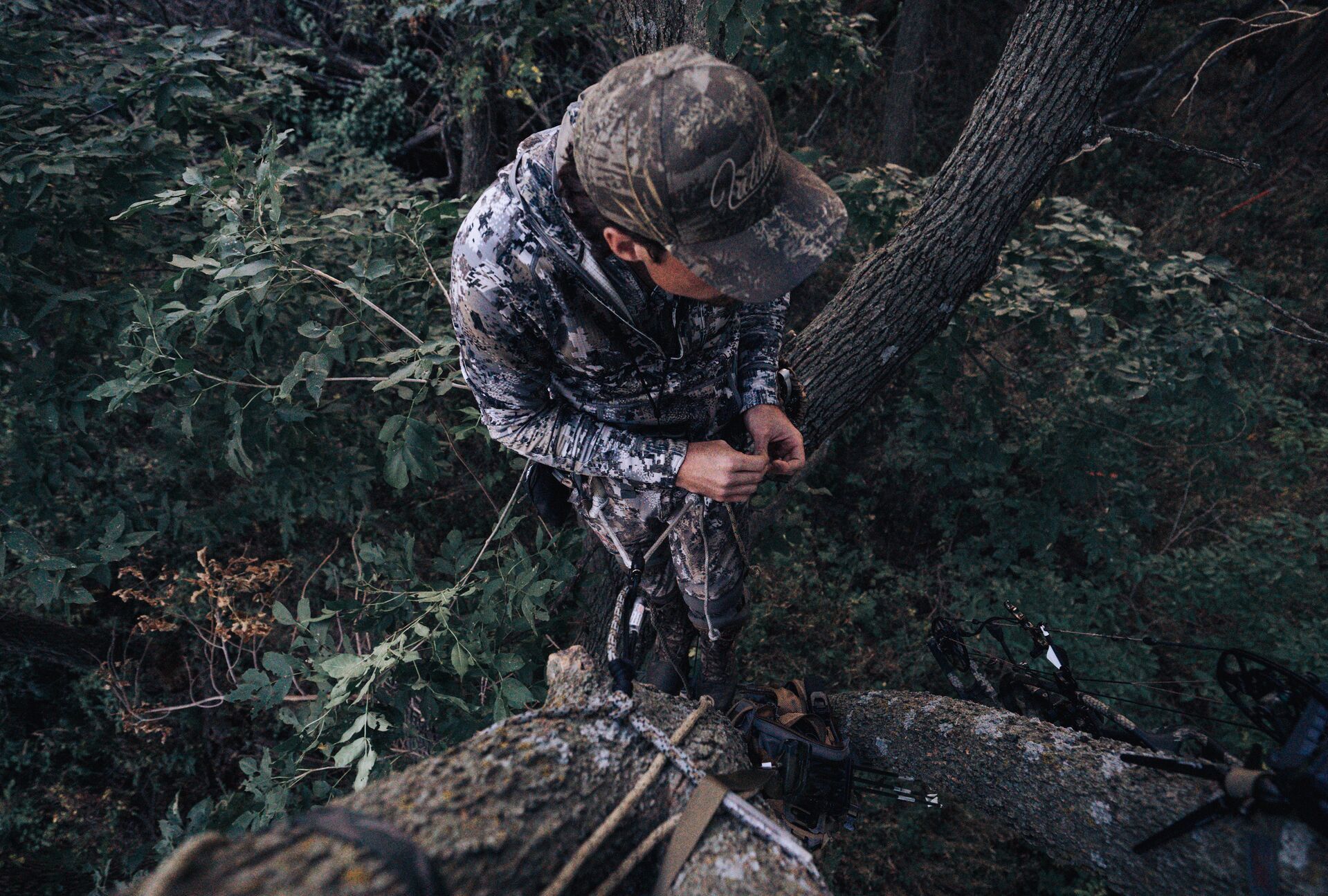 A hunter waits in a tree stand, planning for deer season SC concept.
