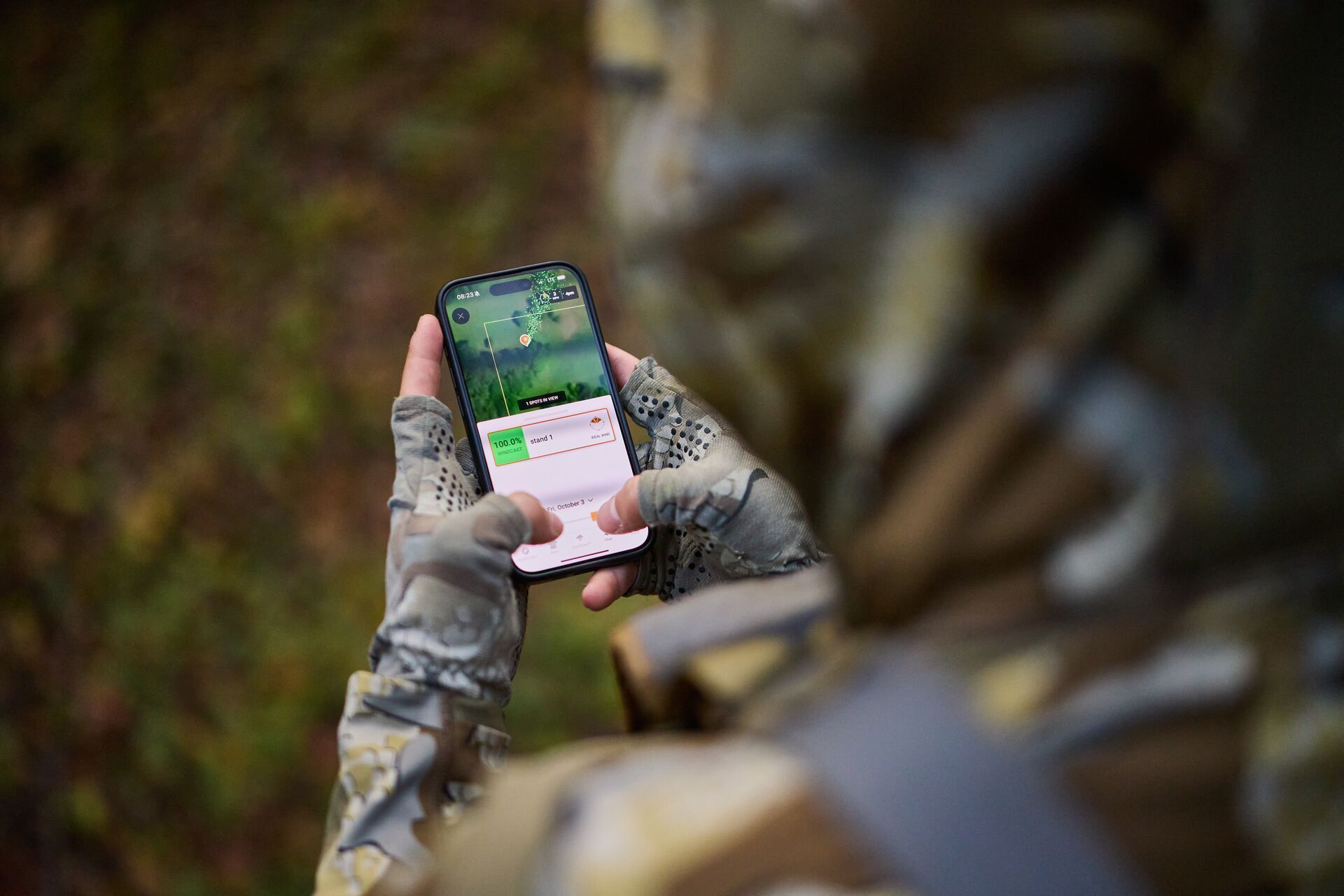 Hunter using HuntWise hunting app on a phone screen.