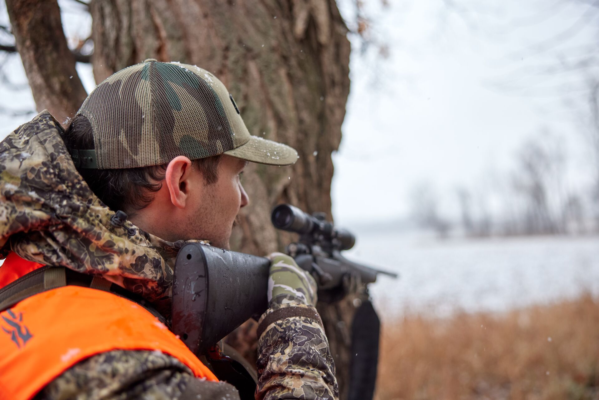 A hunter sighting in a rifle, trophy bucks concept.