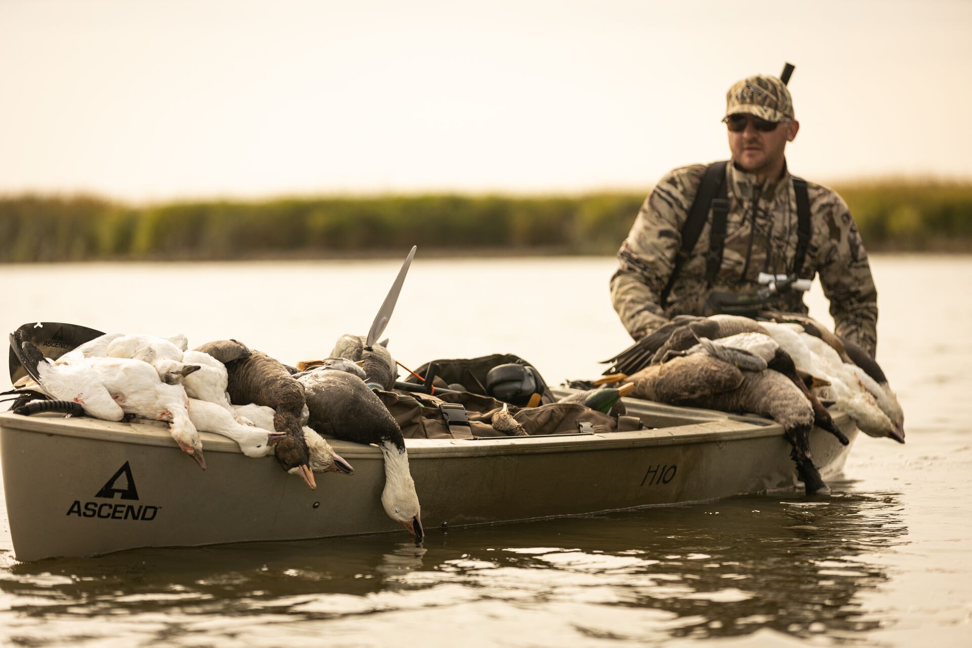 A hunter in a small fishing boat full of geese after a hunt, Nevada hunting seasons concept.