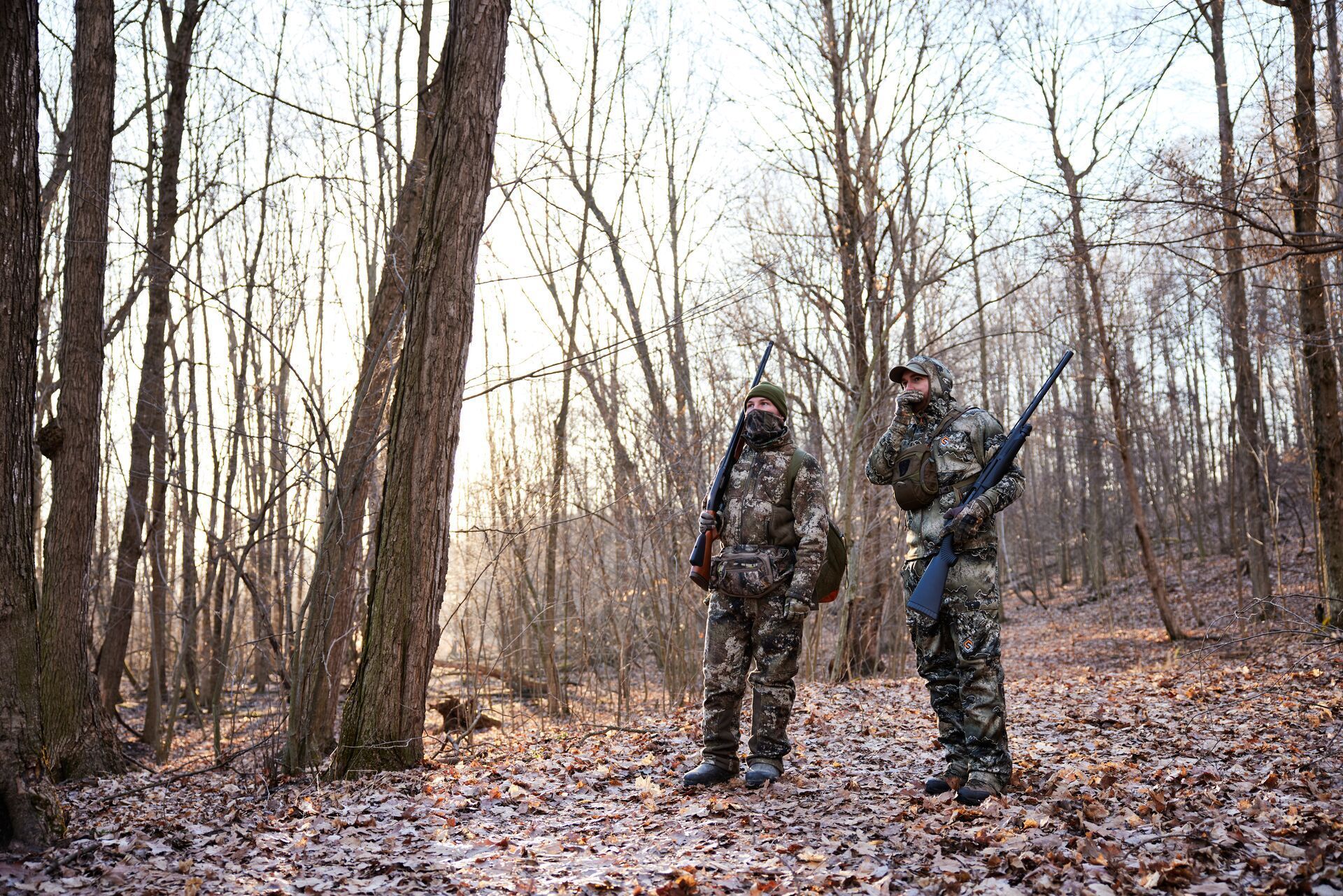 Turkey hunters walk and call in the woods, how to hunt turkey in bad weather concept.