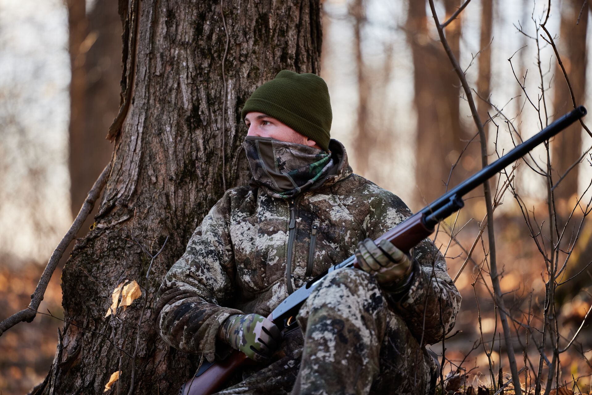 A hunter in camo sits in wait for a turkey, Alabama turkey season concept.