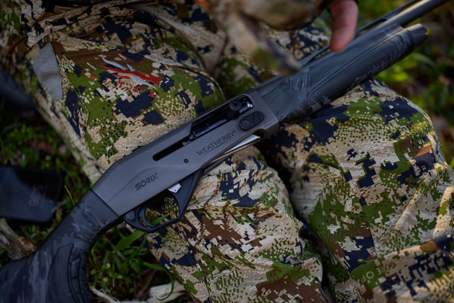 A shotgun lays on a hunter
