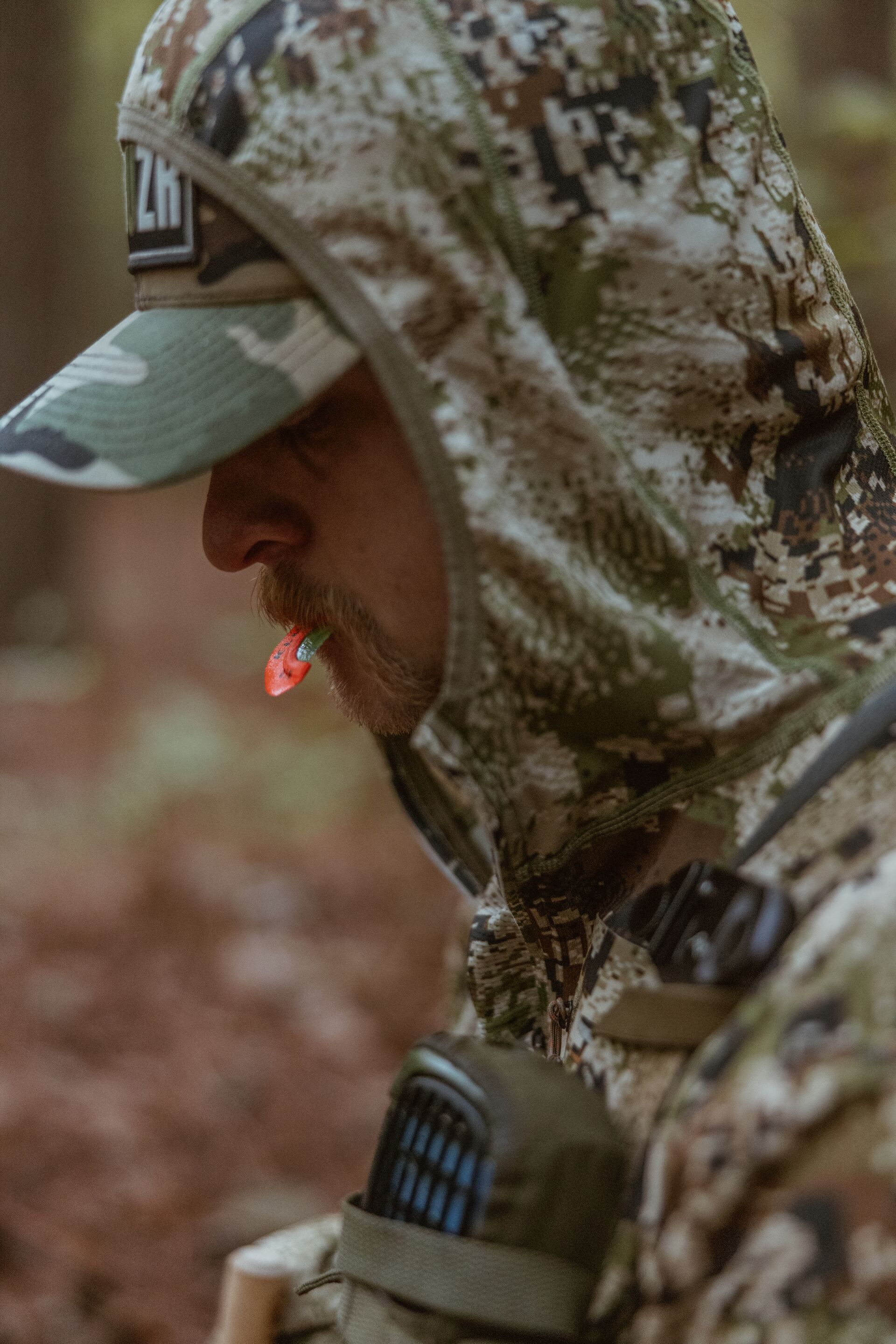 Hunter with a turkey call in his mouth, western turkey hunting strategies concept.