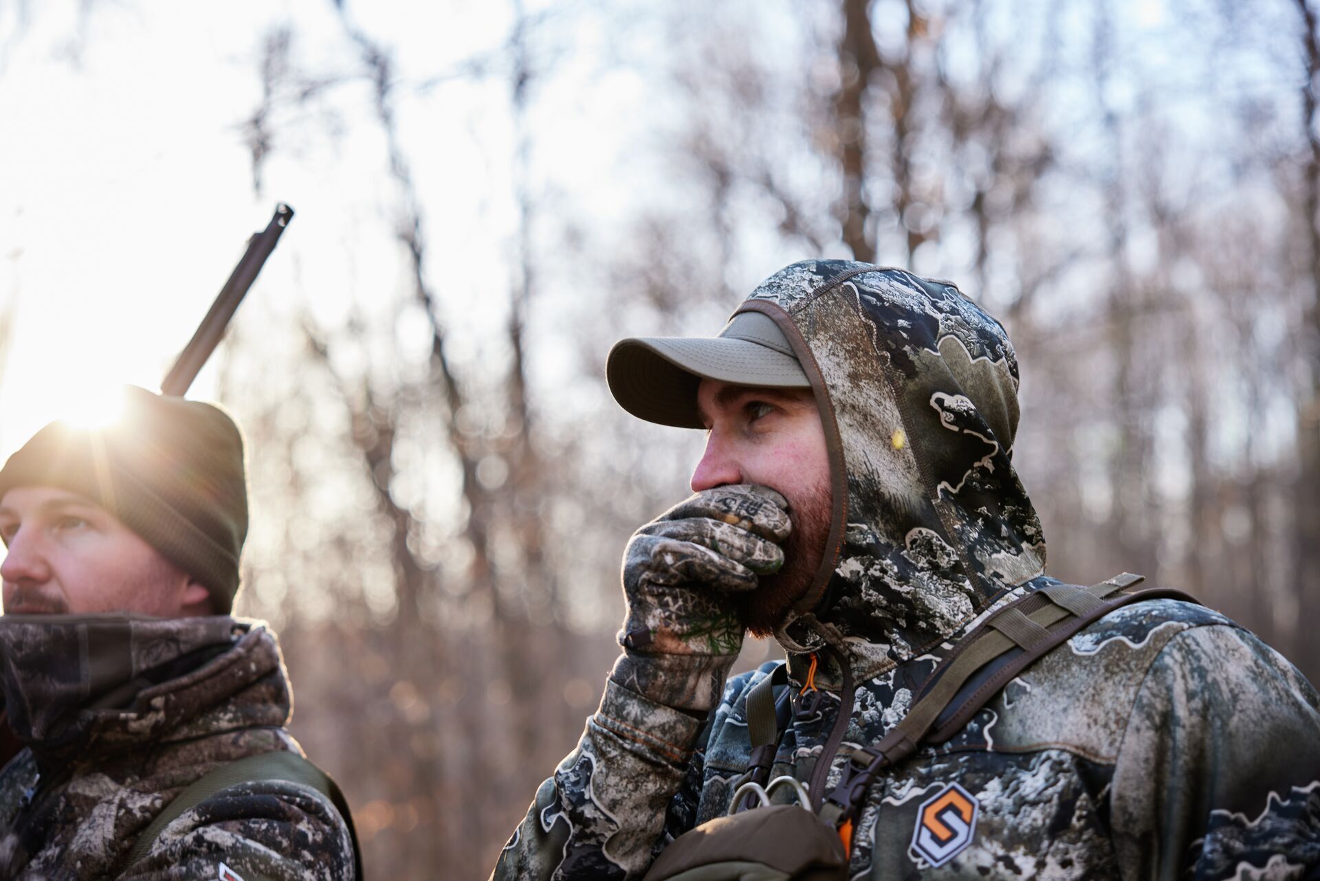 Two hunters in camo calling for turkeys, understanding wild vs heritage turkey concept.