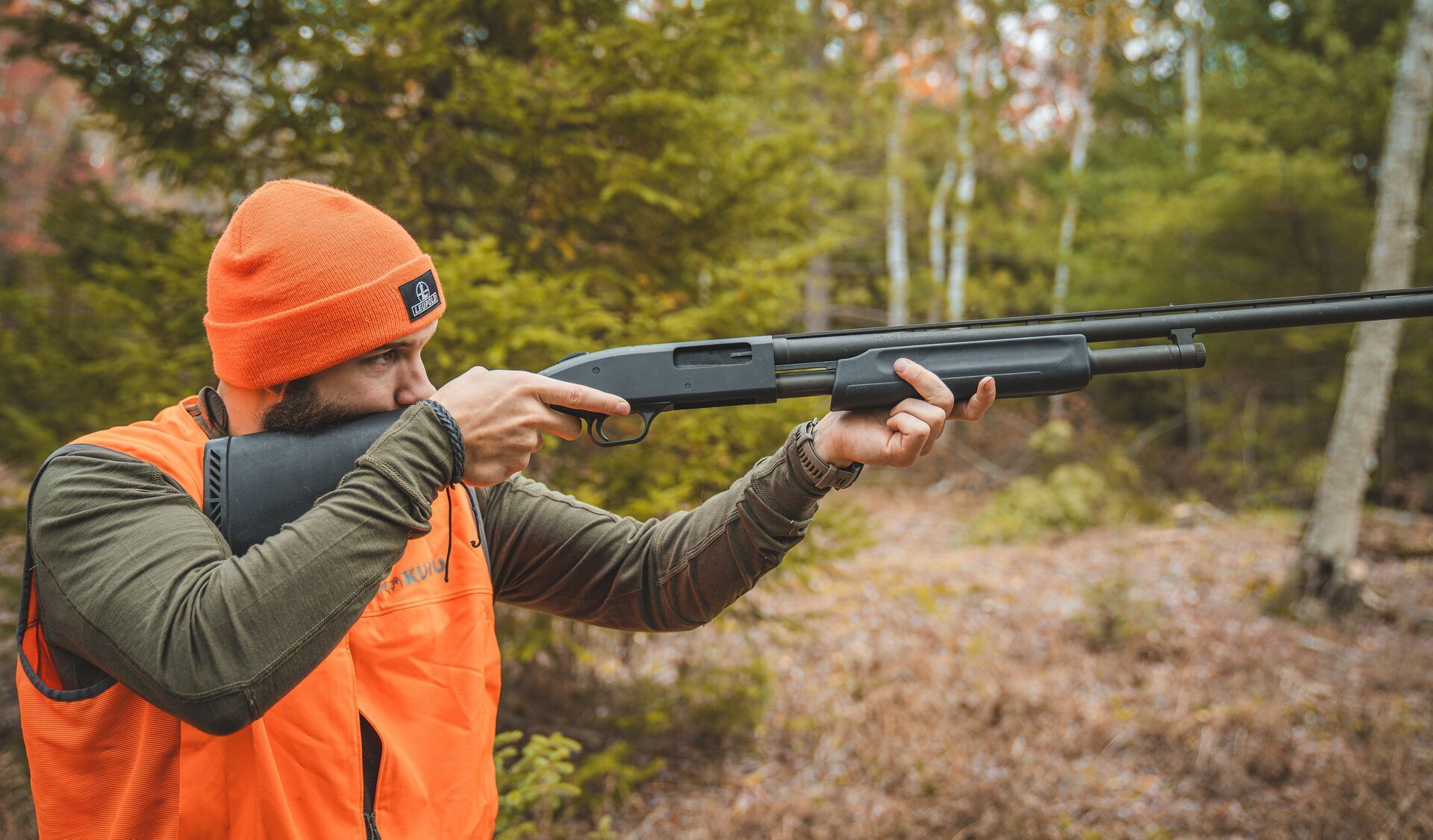 Hunter with pump action shotgun, types of shotgun actions concept.