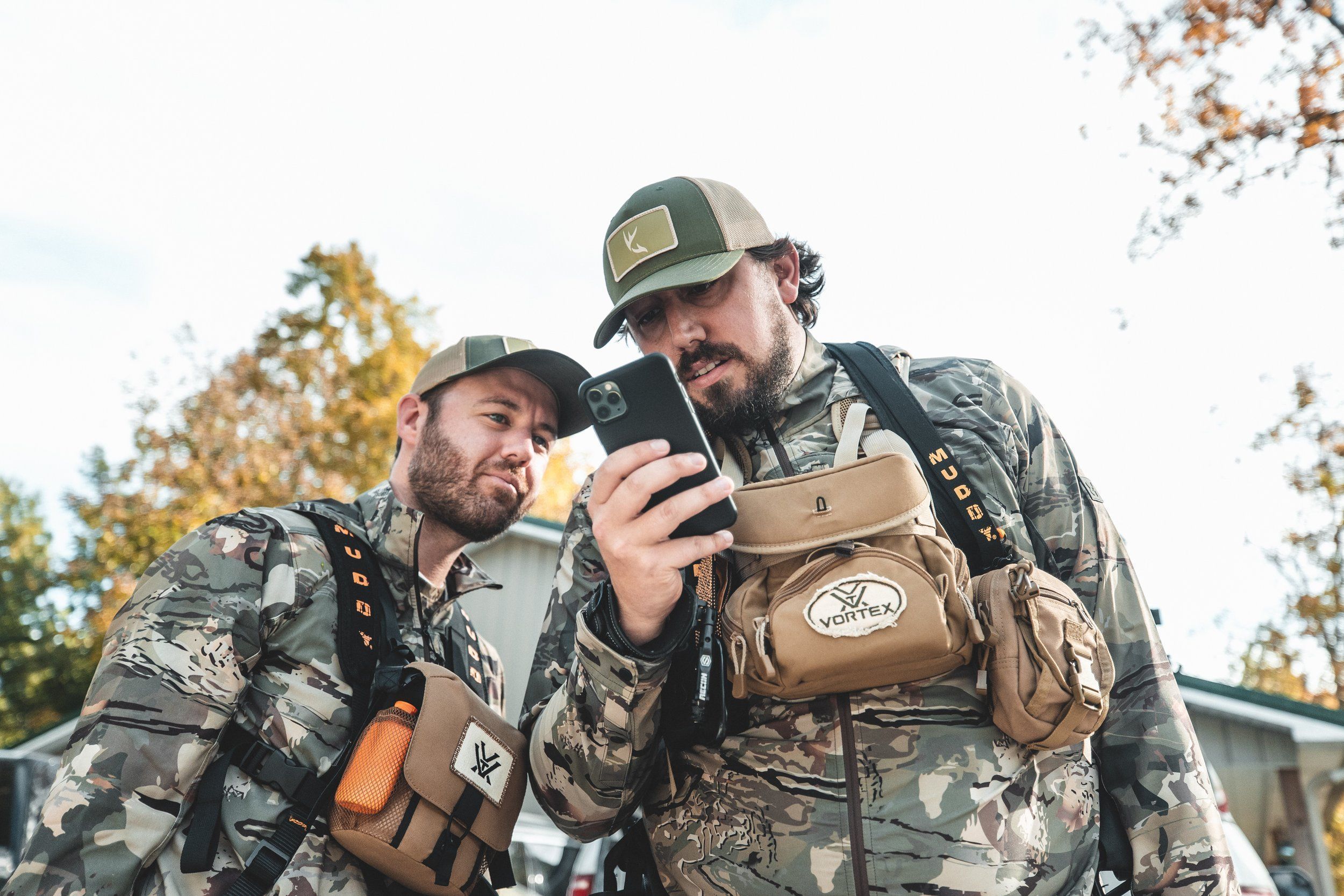 Two hunters using the HuntWise app, best time to hunt whitetail deer concept.