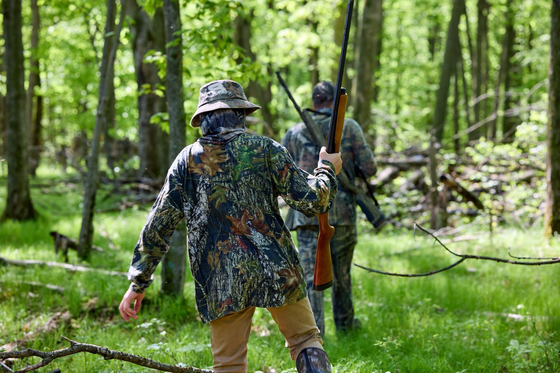 Young hunter with adult in camo in the woods, turkey season Wisconsin concept.