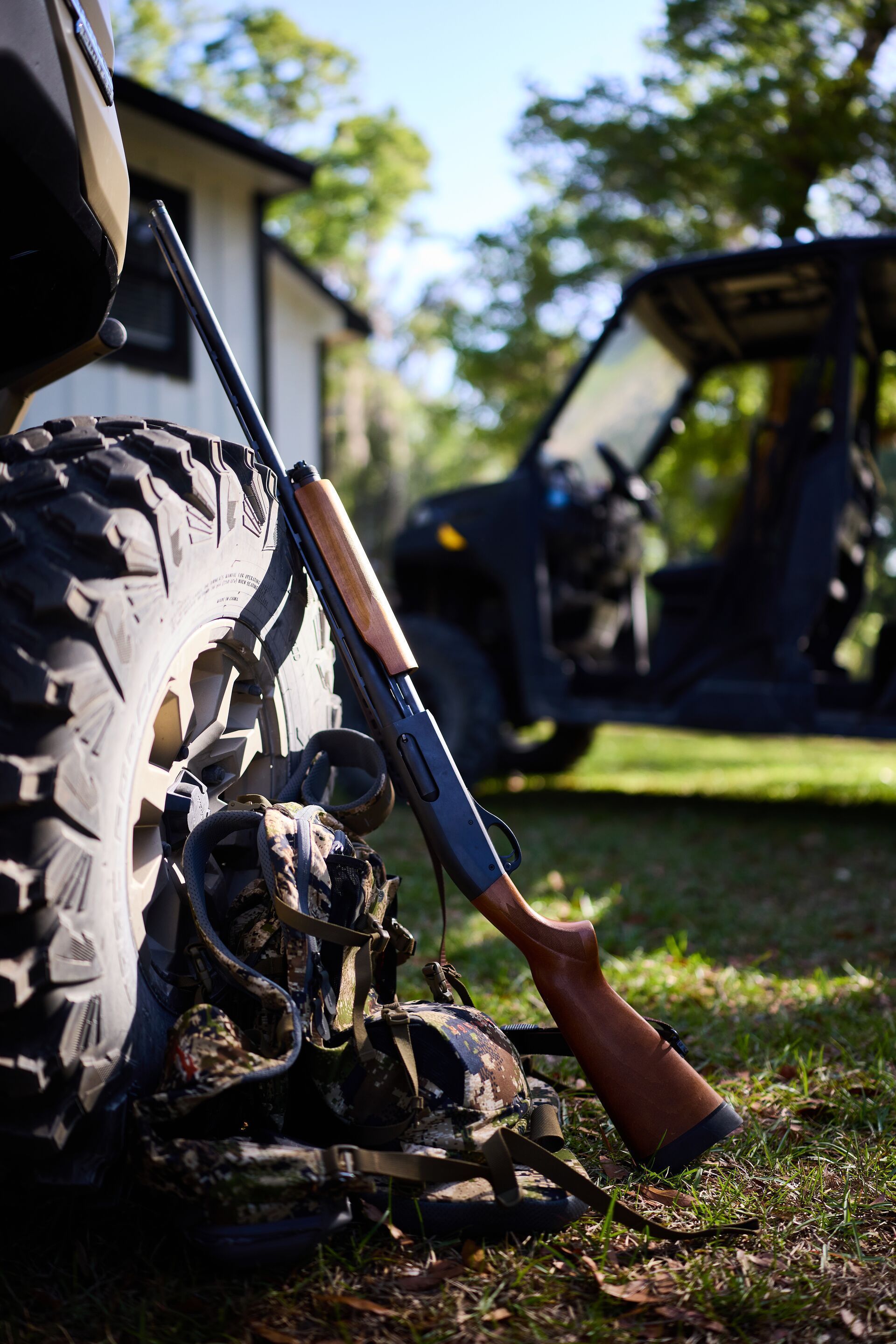 Hunting gear leans against truck tire, spring turkey hunting for beginners.