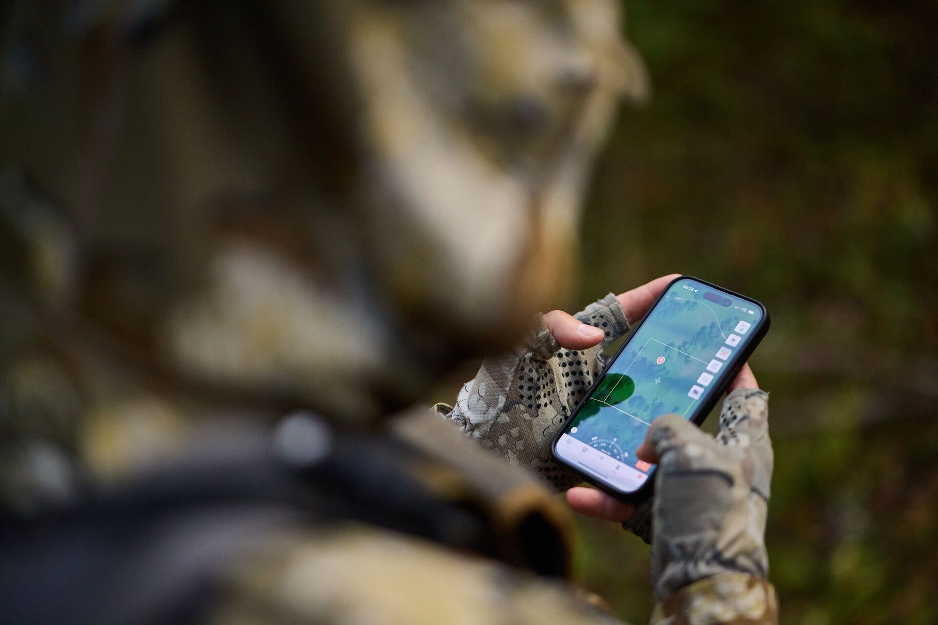 Over the shoulder of hunter looking at HuntWise maps, property lines app concept.