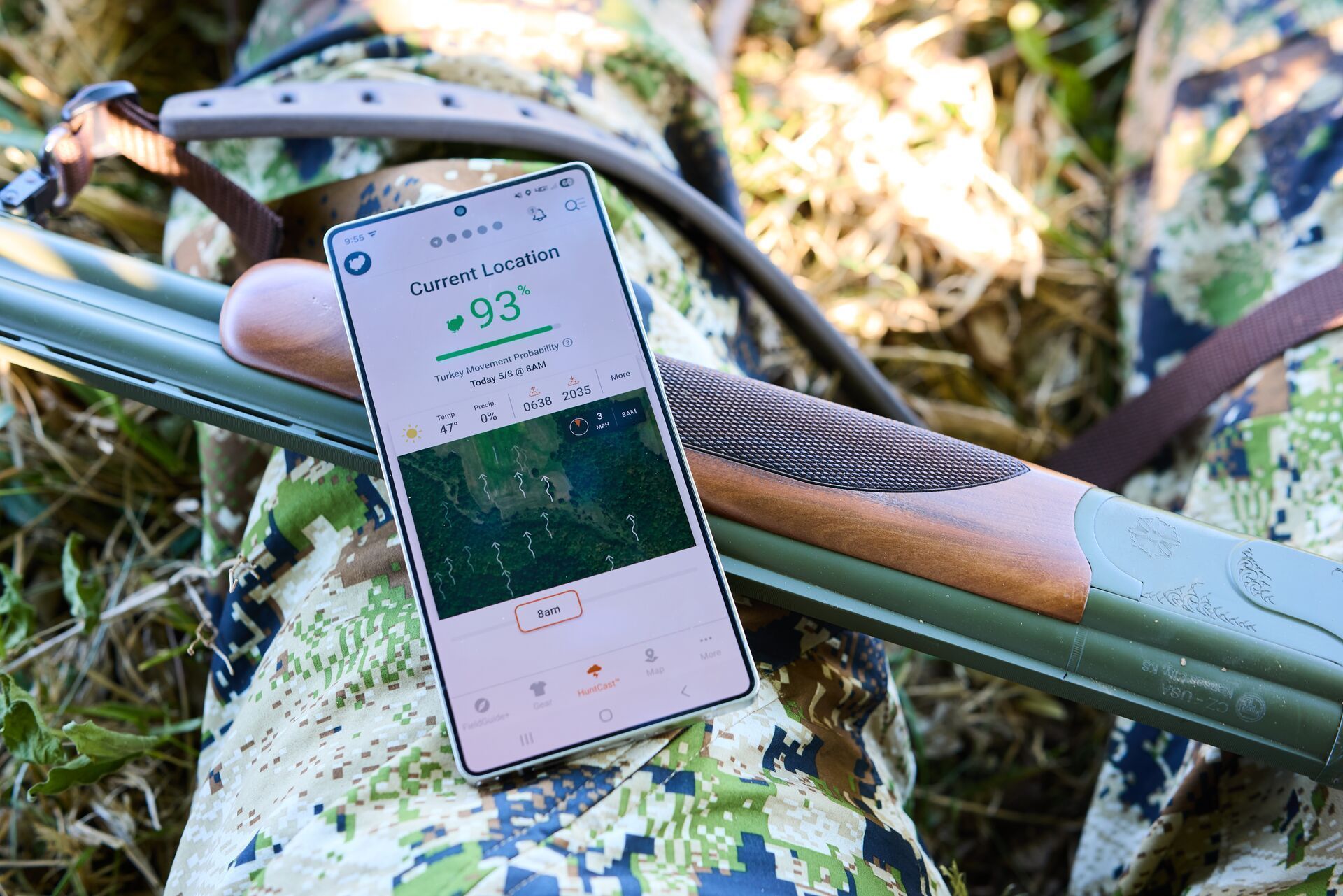 HuntWise on a phone screen leans against firearm barrel, HuntWise review concept.