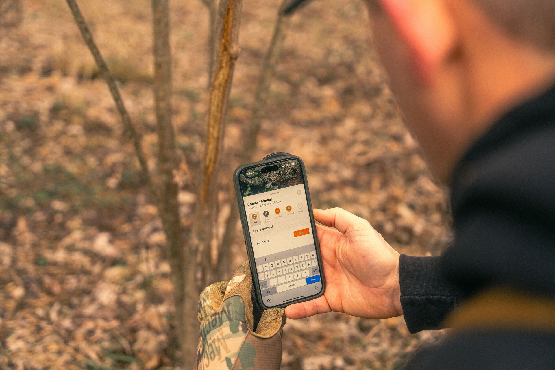 Hunter uses HuntWise to mark a deer rub on a tree.