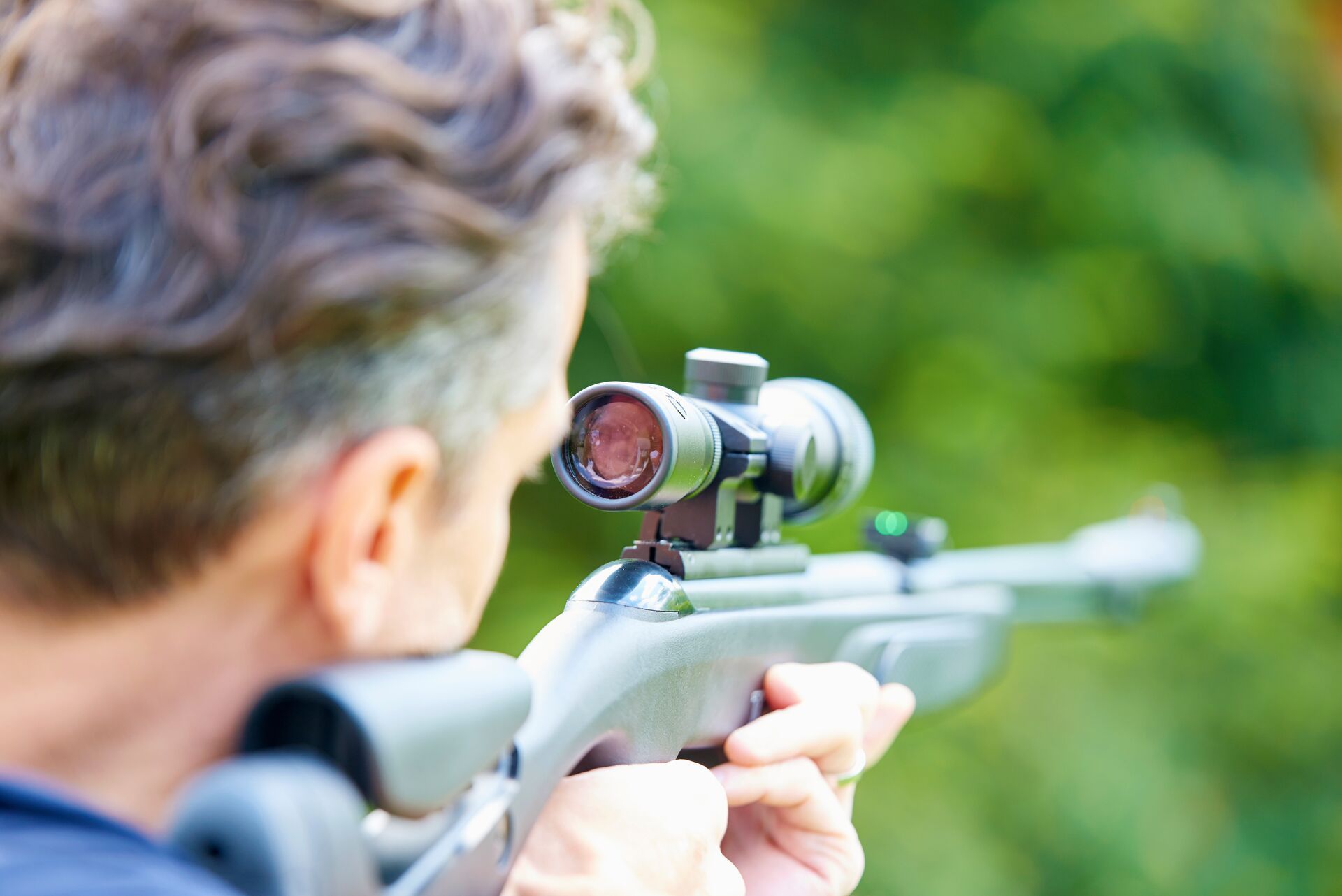 A man aims an air rifle, learning about gun types concept.