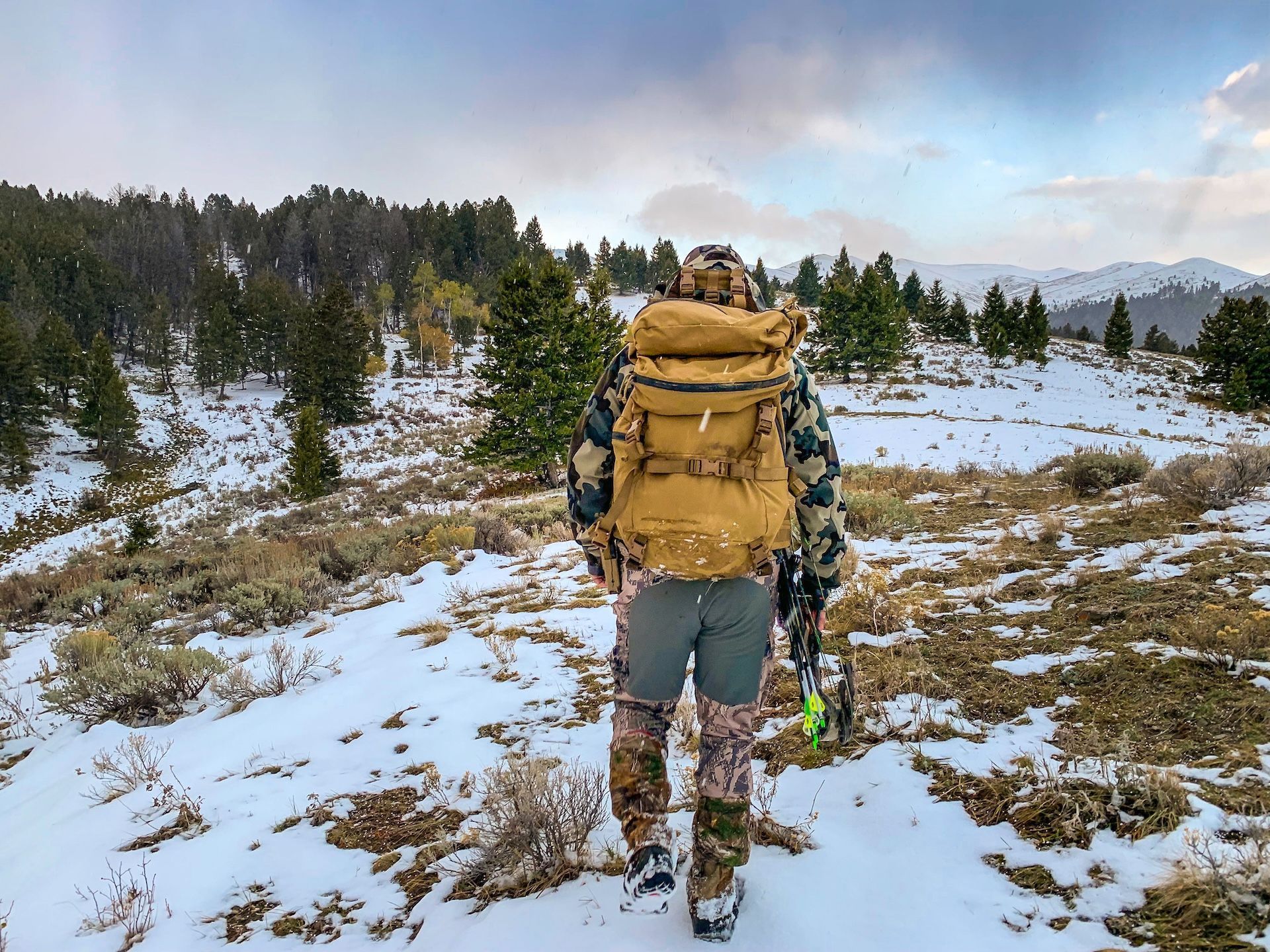 Hunter with gear for an elk hunt with snow on ground.