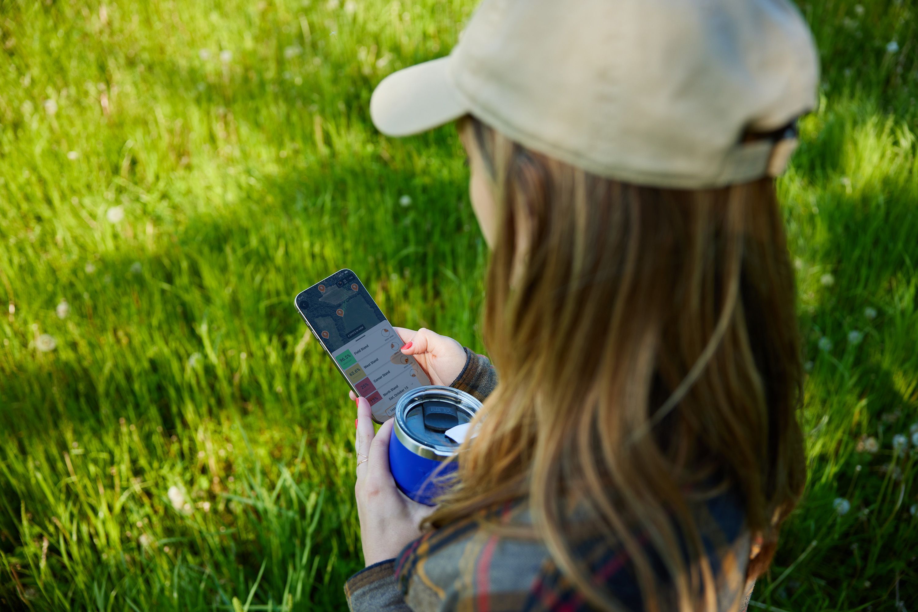 A woman looking at HuntWise on the screen of the phone in her hand, Mississippi hunting season concept.