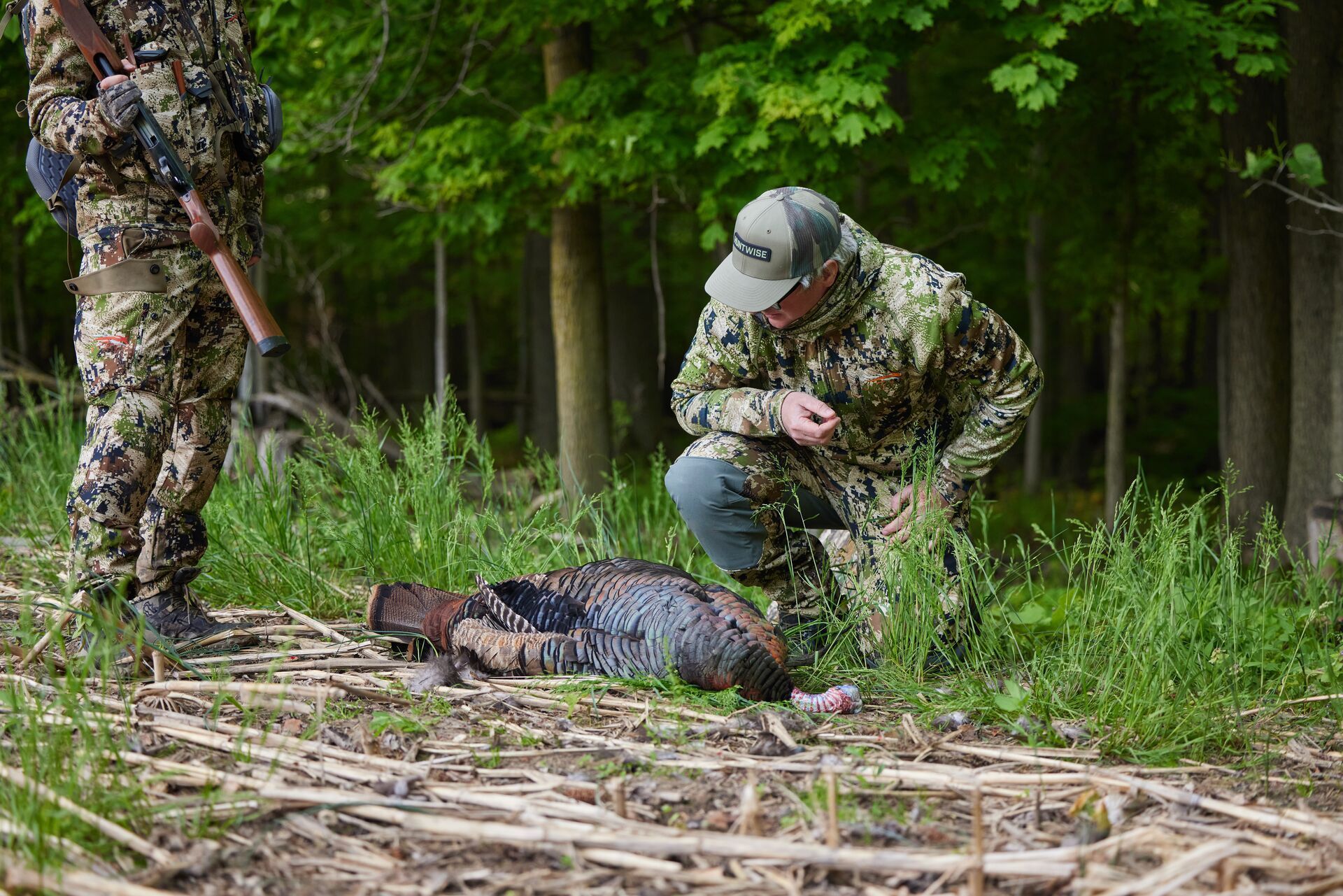 Hunters with a turkey on the ground after a hunt.