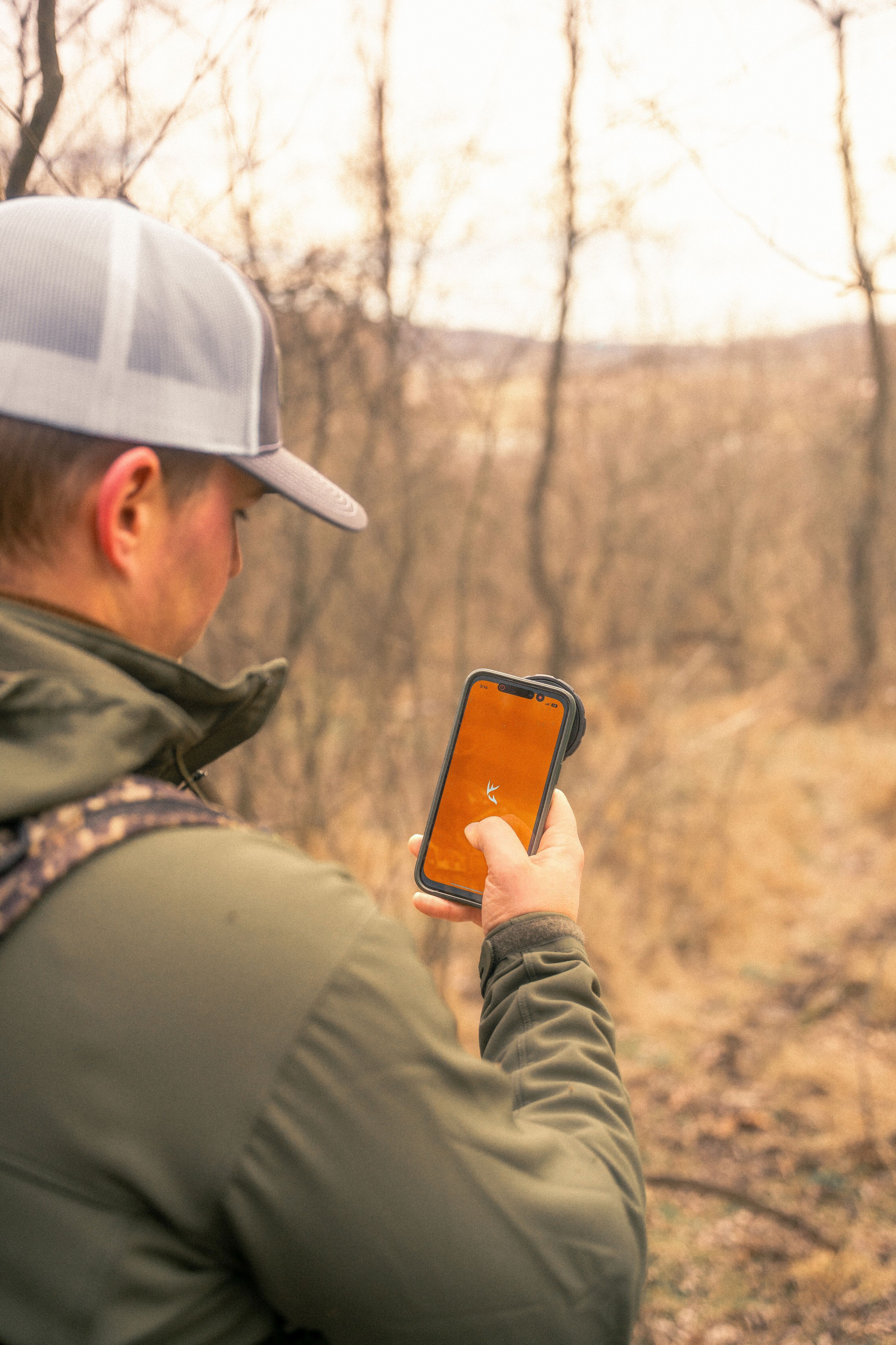 A hunter using the HuntWise hunting app on a cellphone.