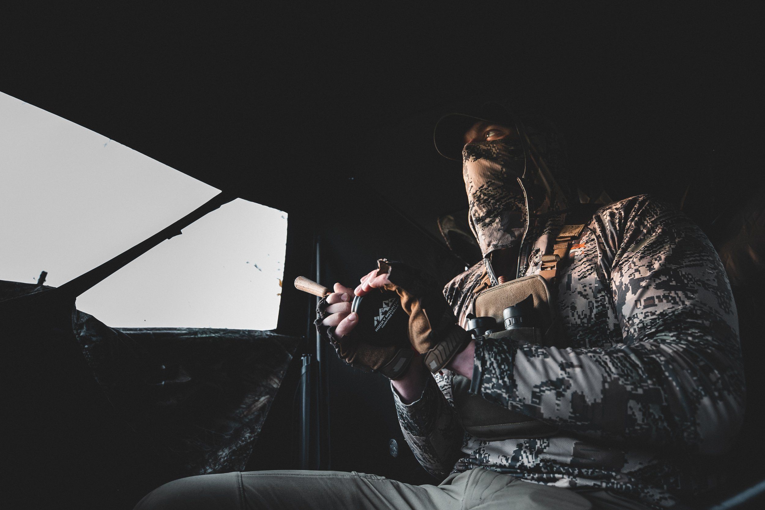 Hunter in a turkey blind uses a slate call.