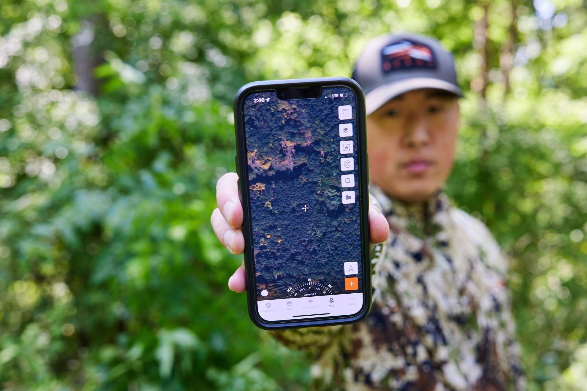 Hunter showing the HuntWise hunting app on a cellphone screen.