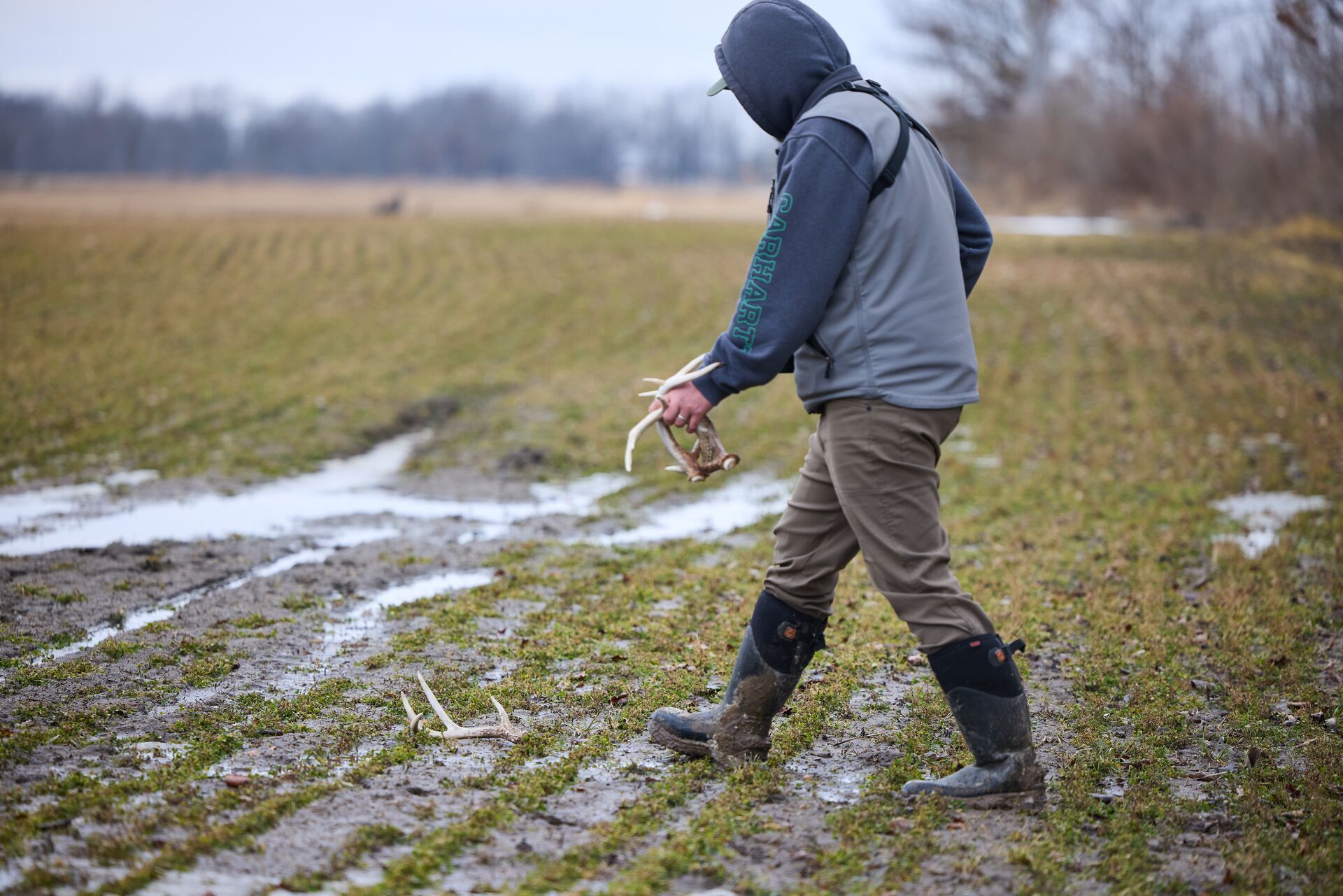 A hunter picks up shed antlers.