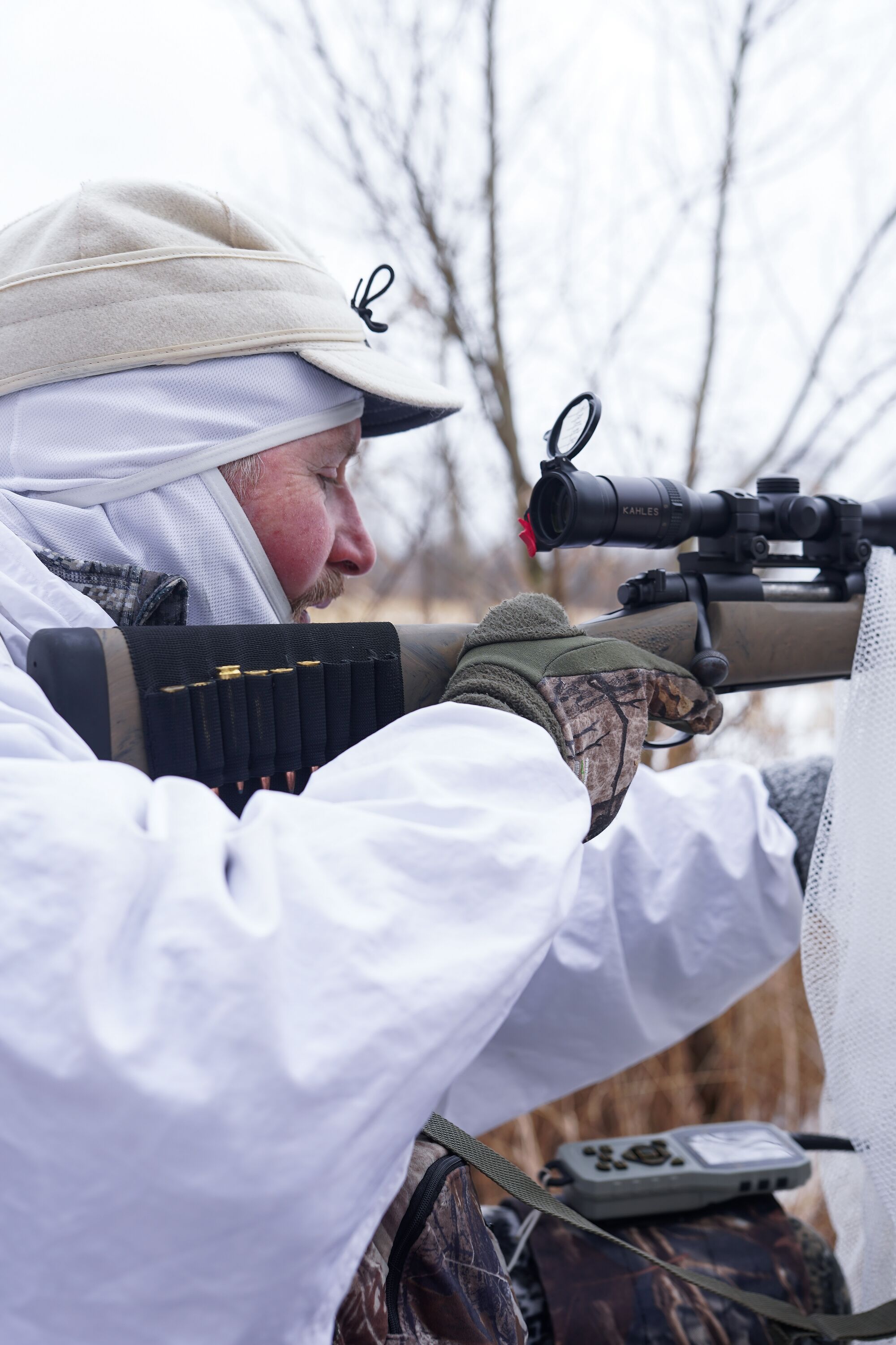 Hunter in white gear for snowy hunt.