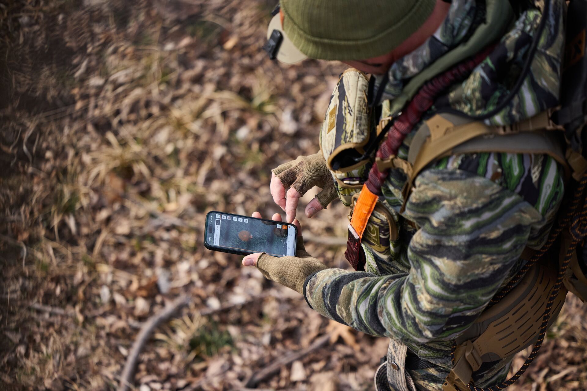 Hunter using a hunting land app in the field.