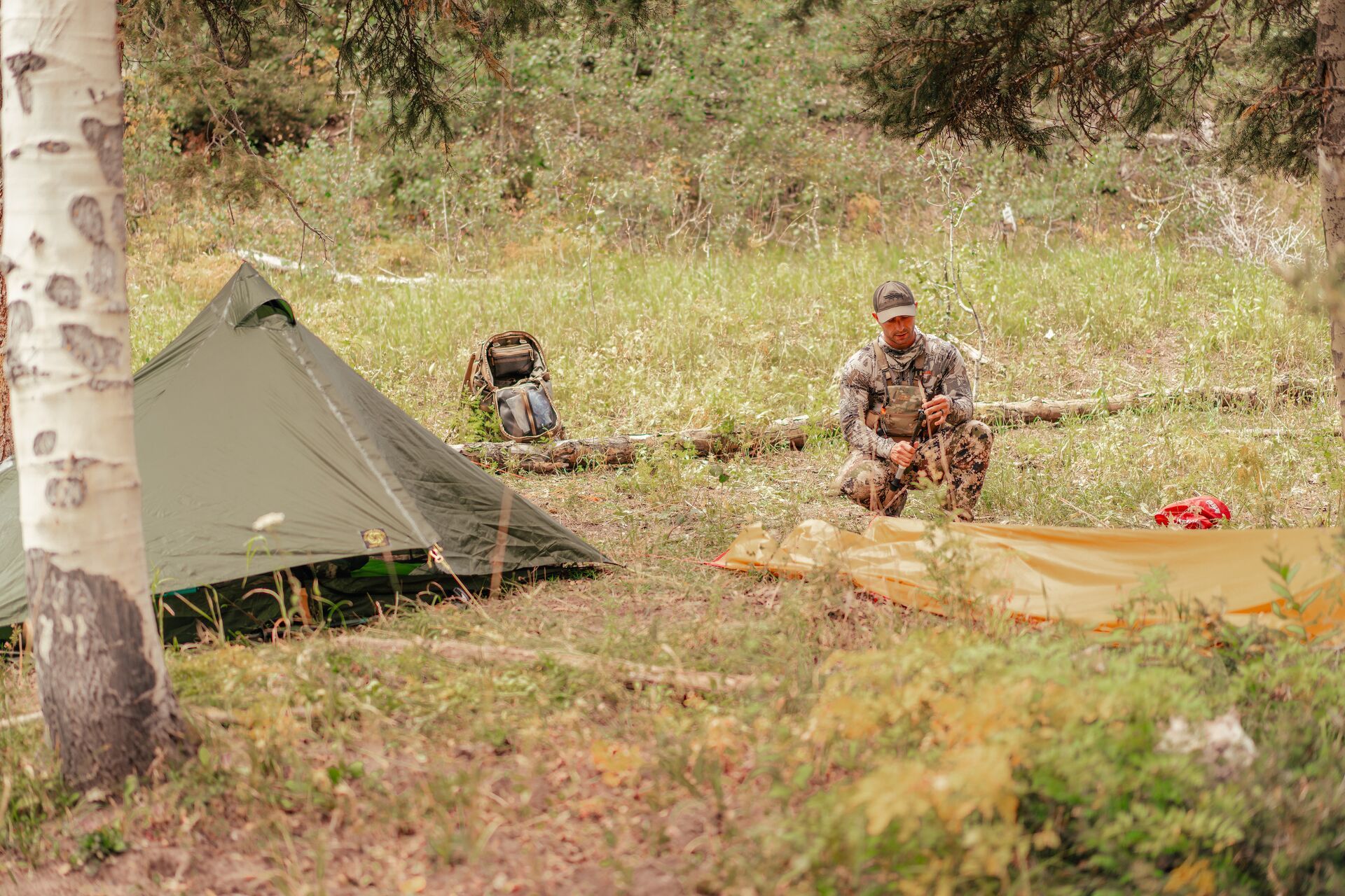 Hunter sets up camp, gear for elk hunting concept.