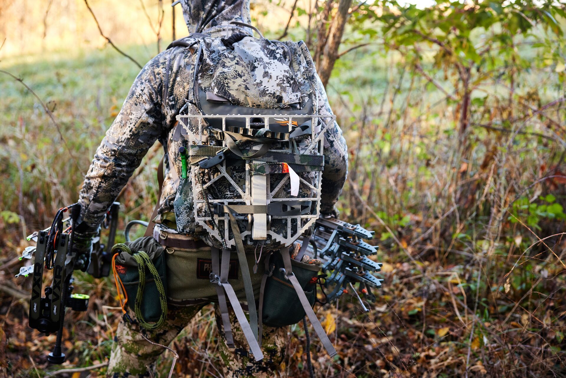 A hunter carries gear to set up a tree stand.