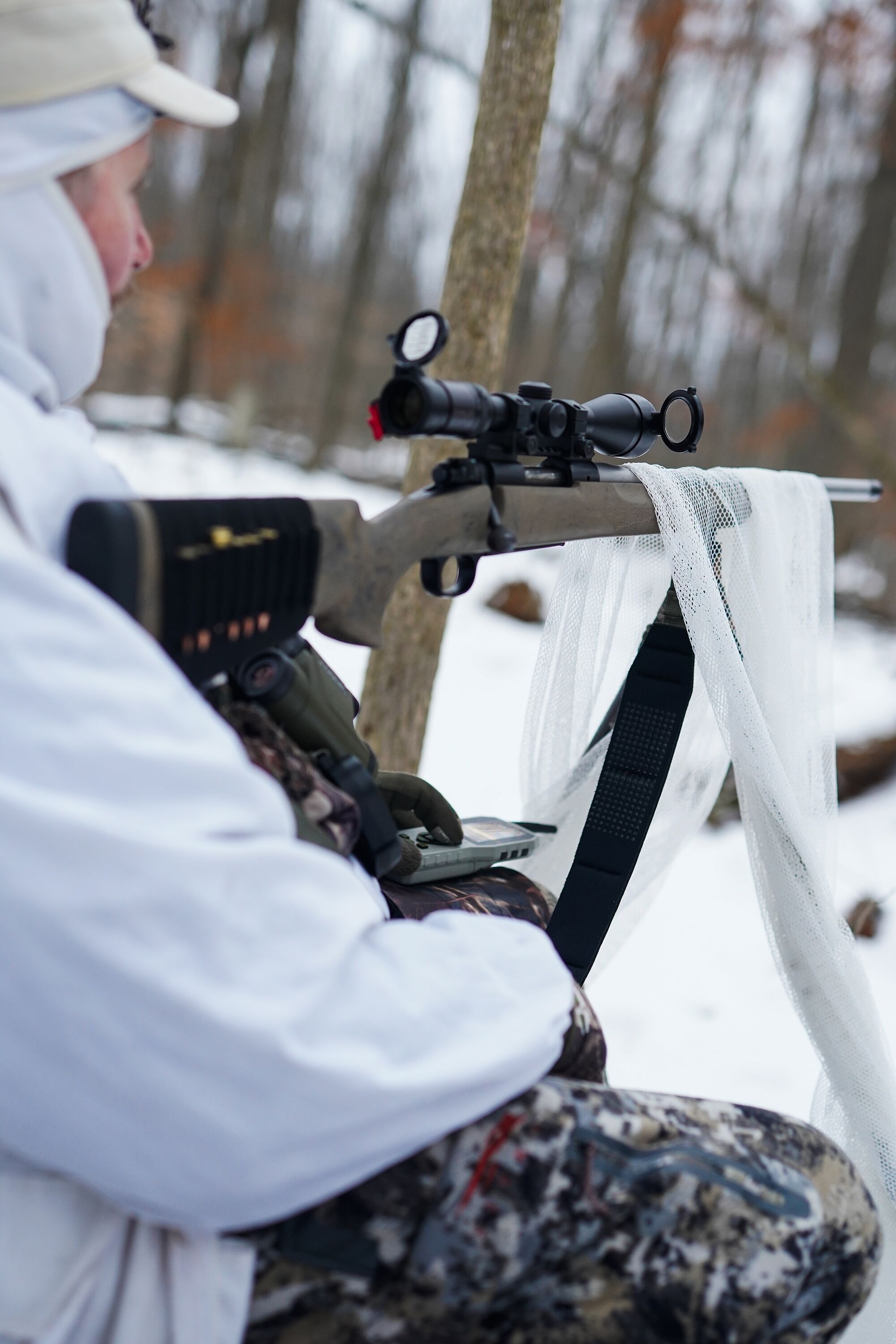 Hunter set up in woods for coyote hunt, hunting invasive species concept.