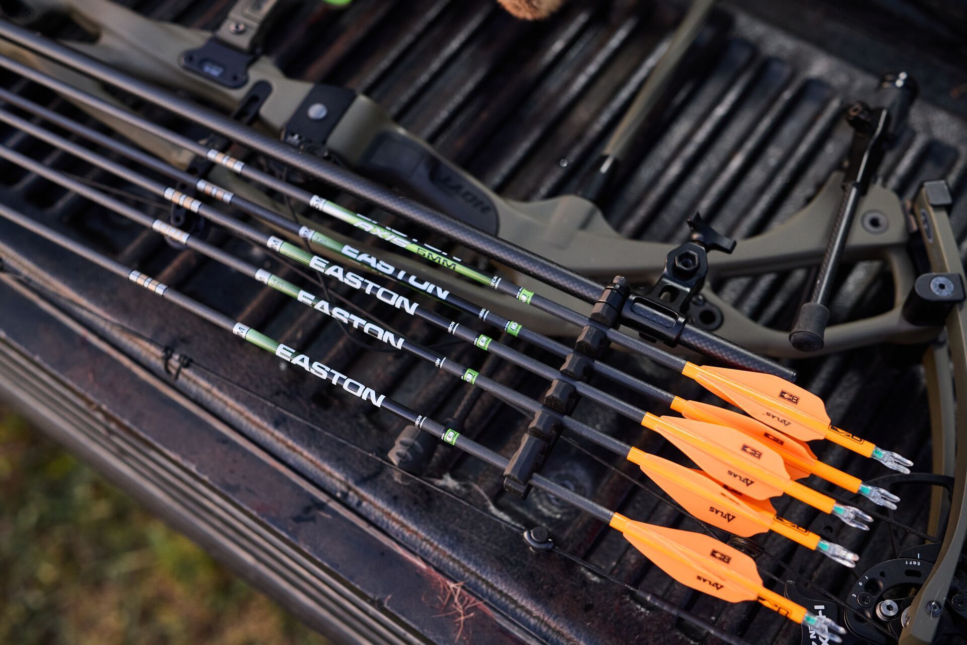Arrows lay neatly near bow, bow hunting gear storage concept.
