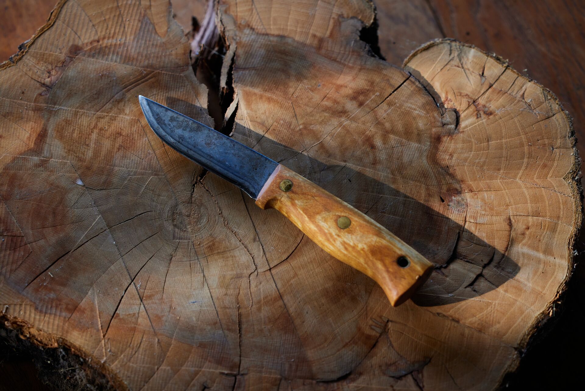 A fixed-blade knife with a wooden handle, consider the handle when choosing hunting knives concept.