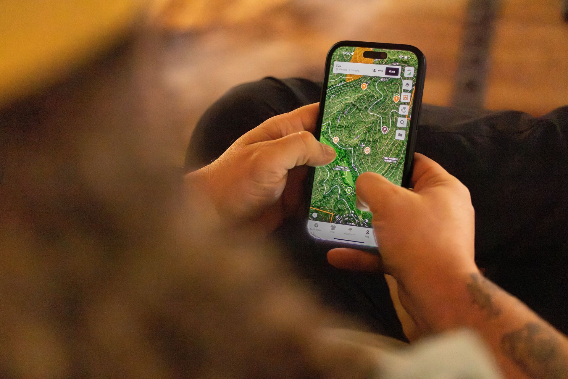 Hunter looking at phone showing HuntWise map.