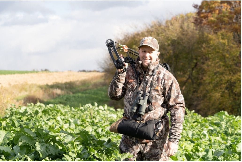 Jeff Sturgis with a bow standing in a food plot.