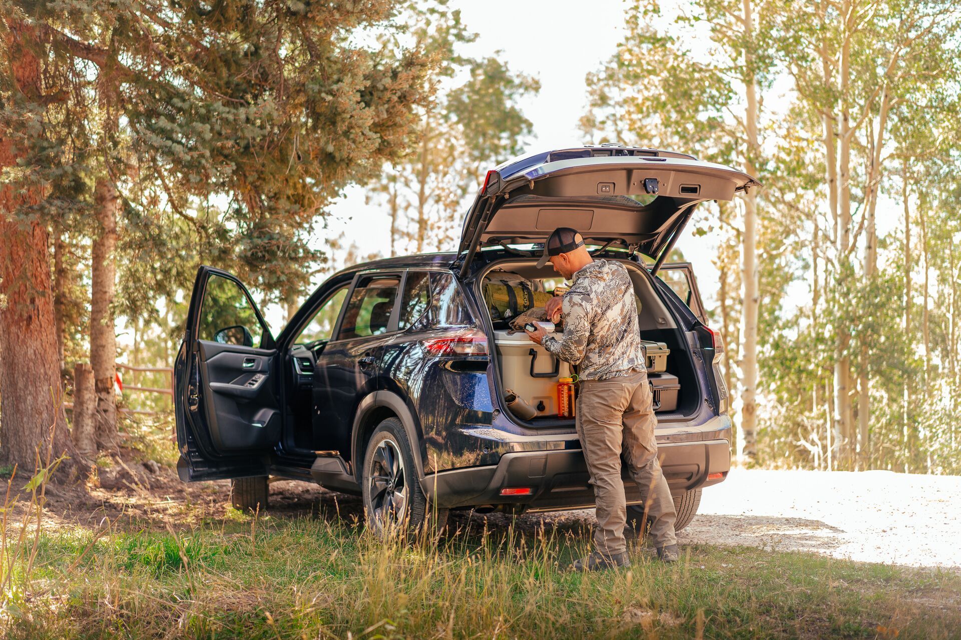 A hunter accesses hunting gear in the back of a car.