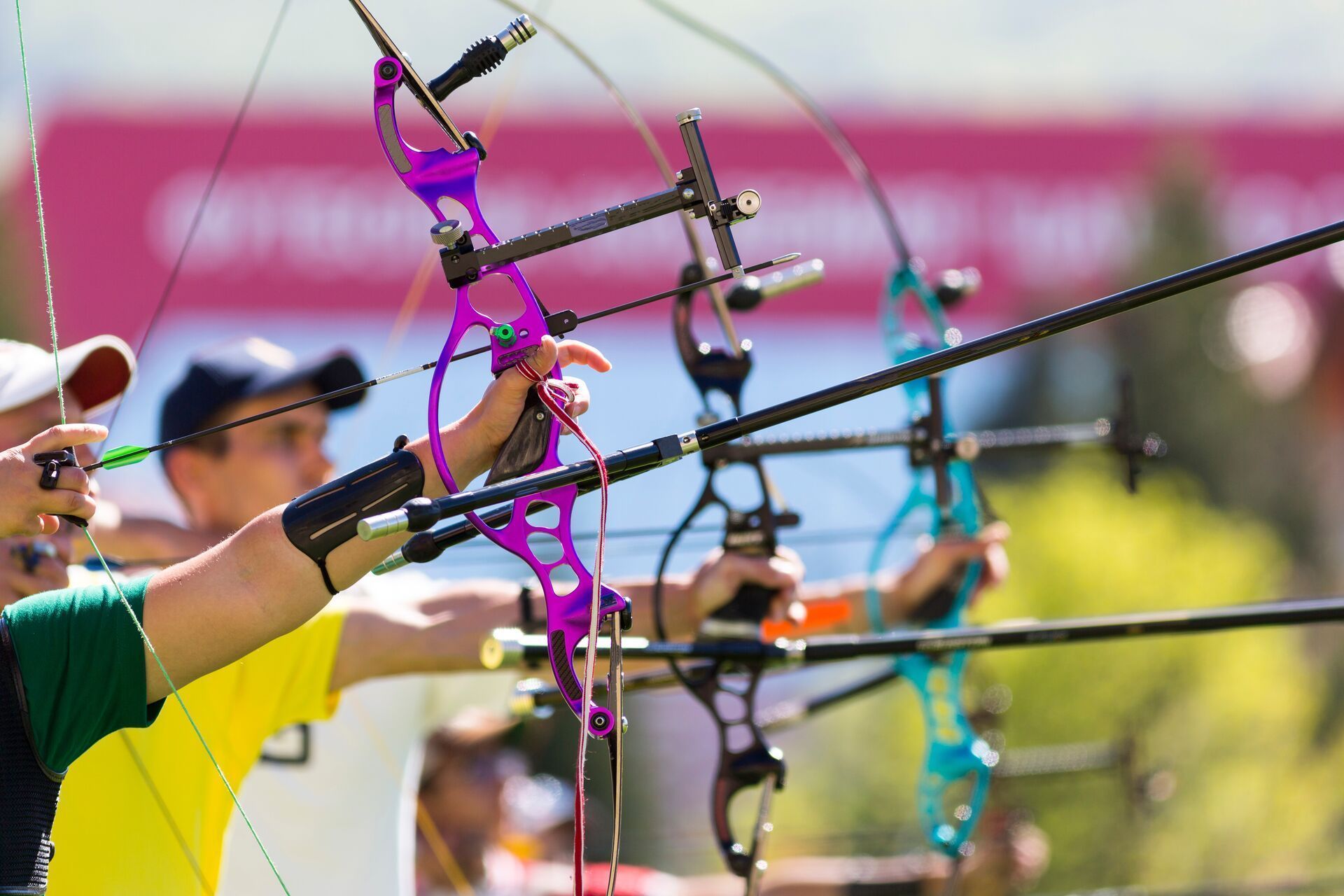 Archers draw back recurve bows.