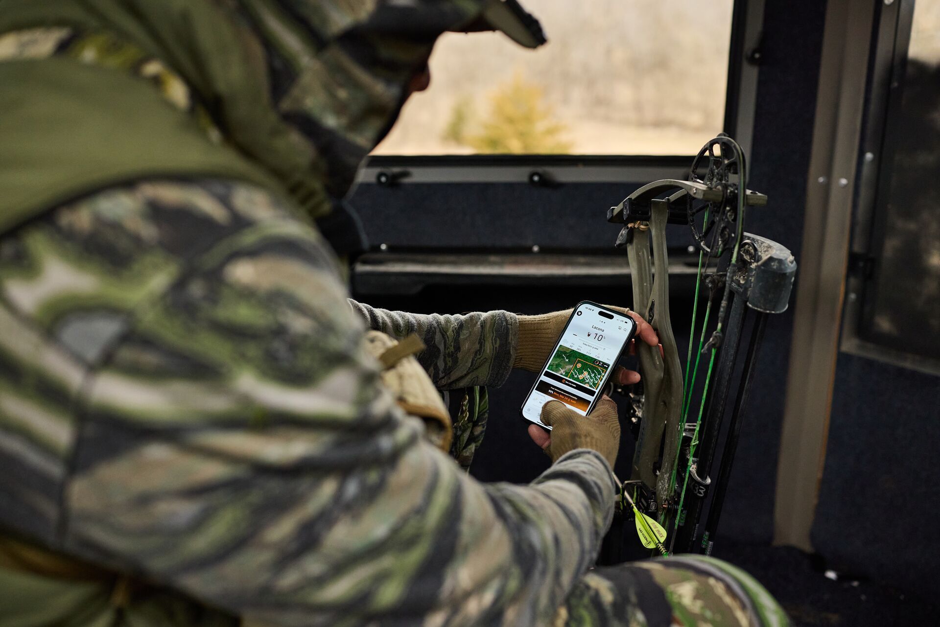 A hunter uses HuntWise on a phone while in a blind, how to build a ground blind concept.