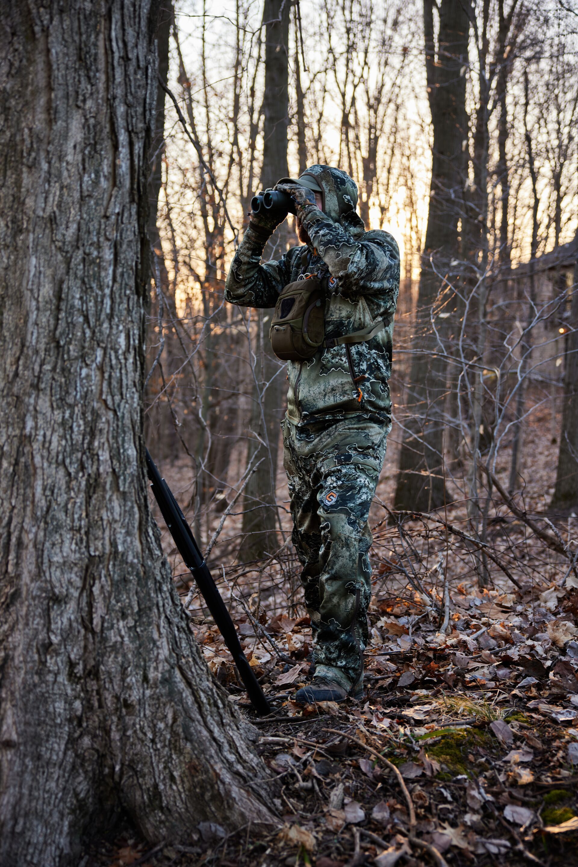 Hunter uses hunting binoculars in the field.